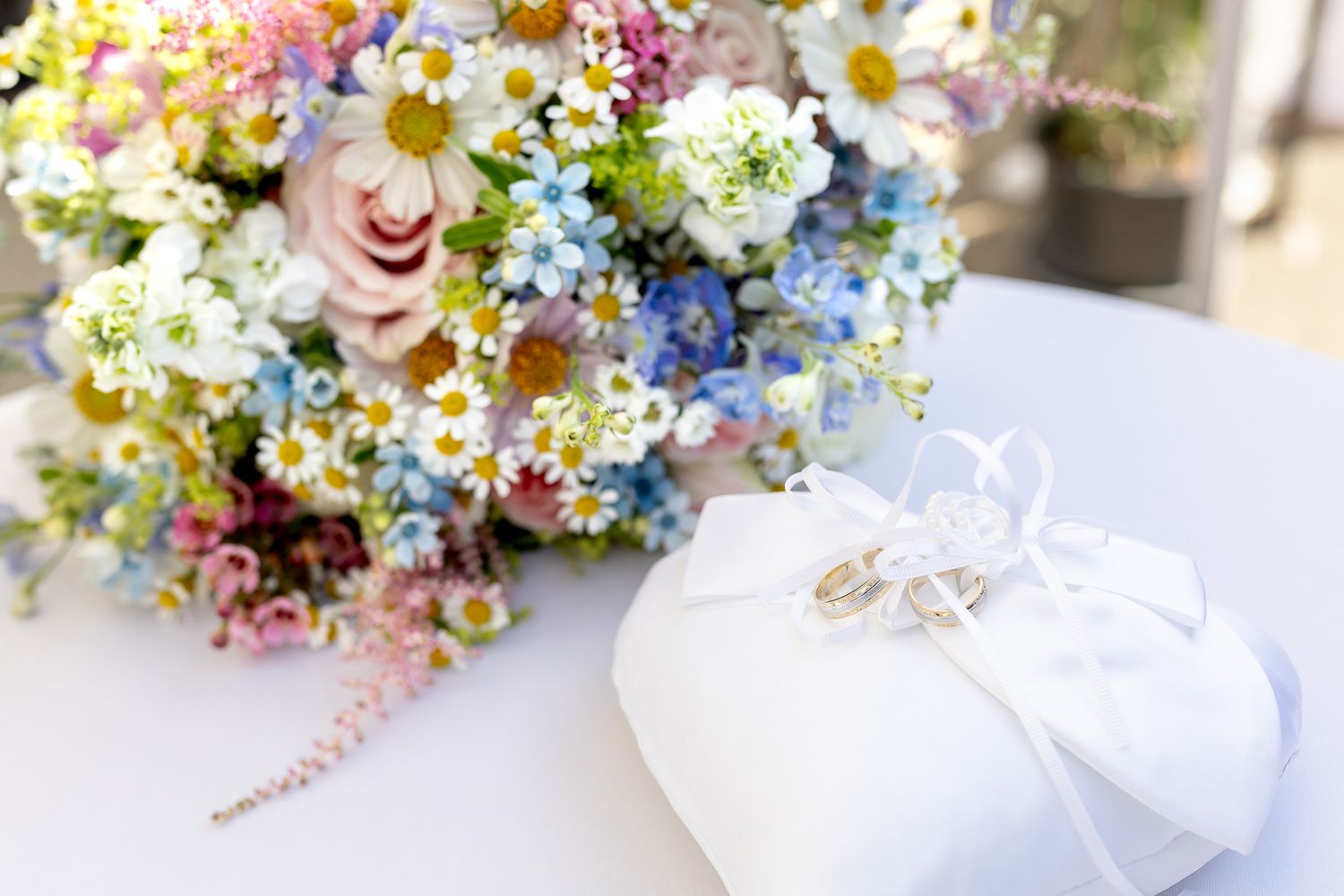 Colorful floral bouquets with pink, purple, and white flowers arranged in a rustic garden style for a wedding celebration.