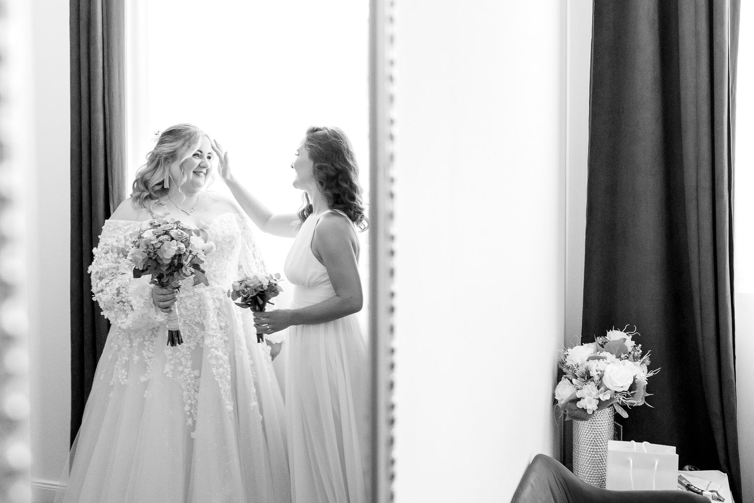 A black and white wedding photo series showing a bride getting ready in front of vanity mirrors.