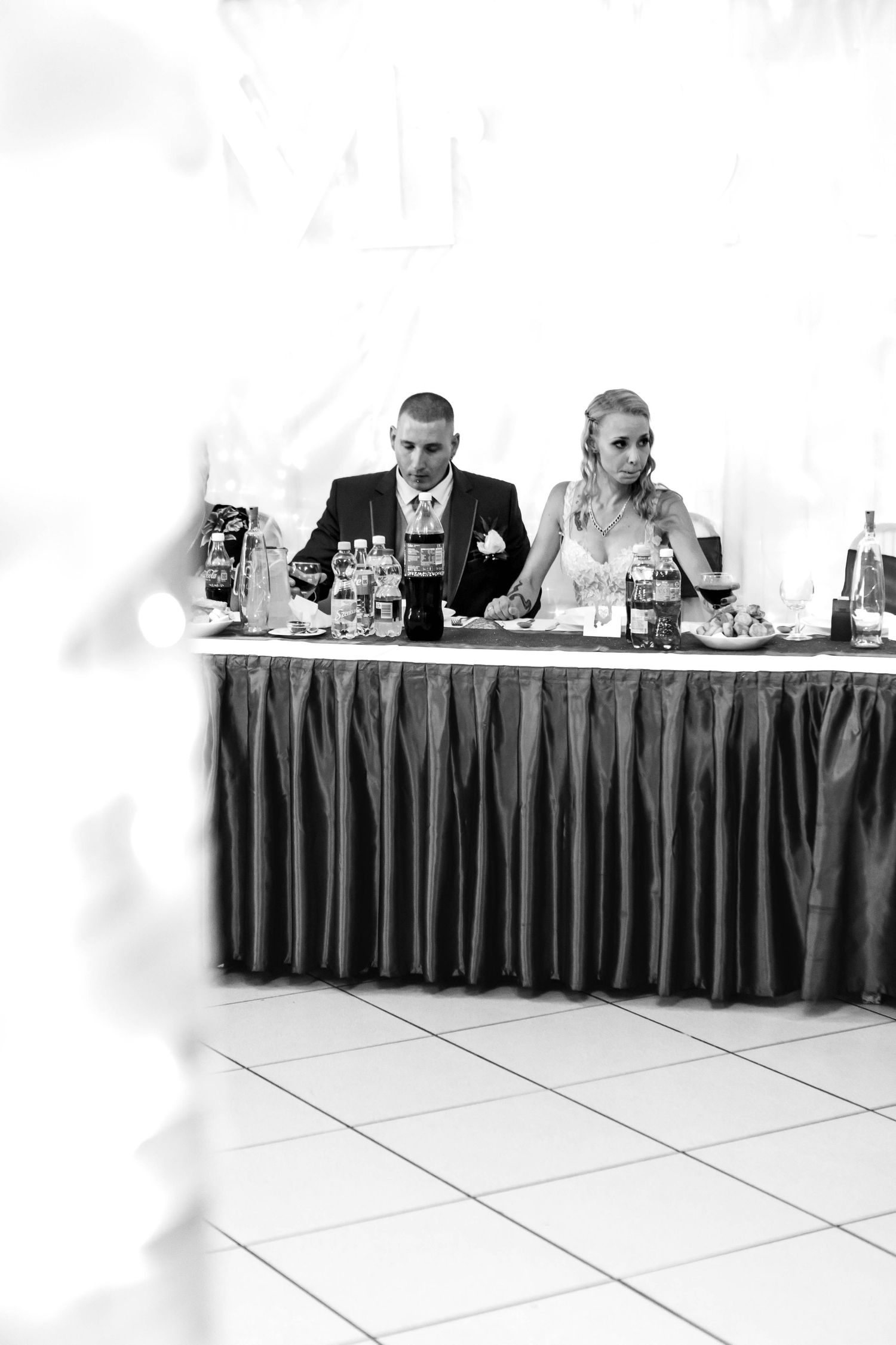Several people seated at a long table with black skirting during what appears to be a formal meeting or conference.