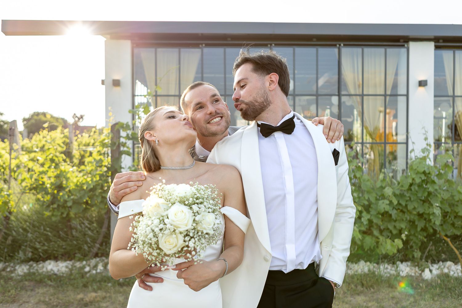 Wedding party enjoying candid moments outside modern venue.