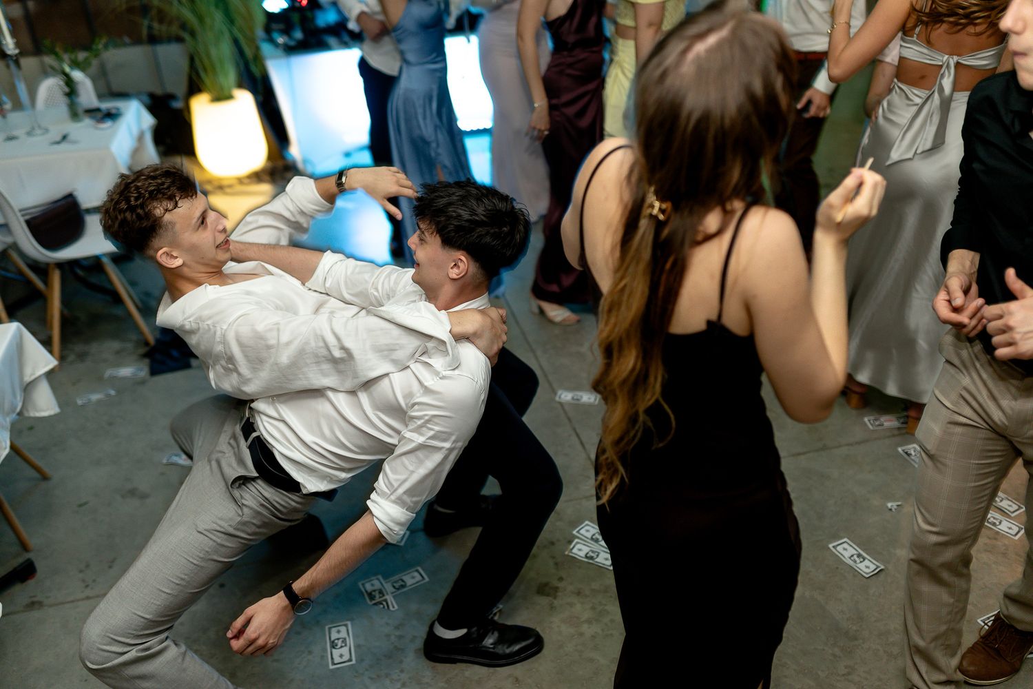 Party guests dancing on a dark dance floor at a celebration event.