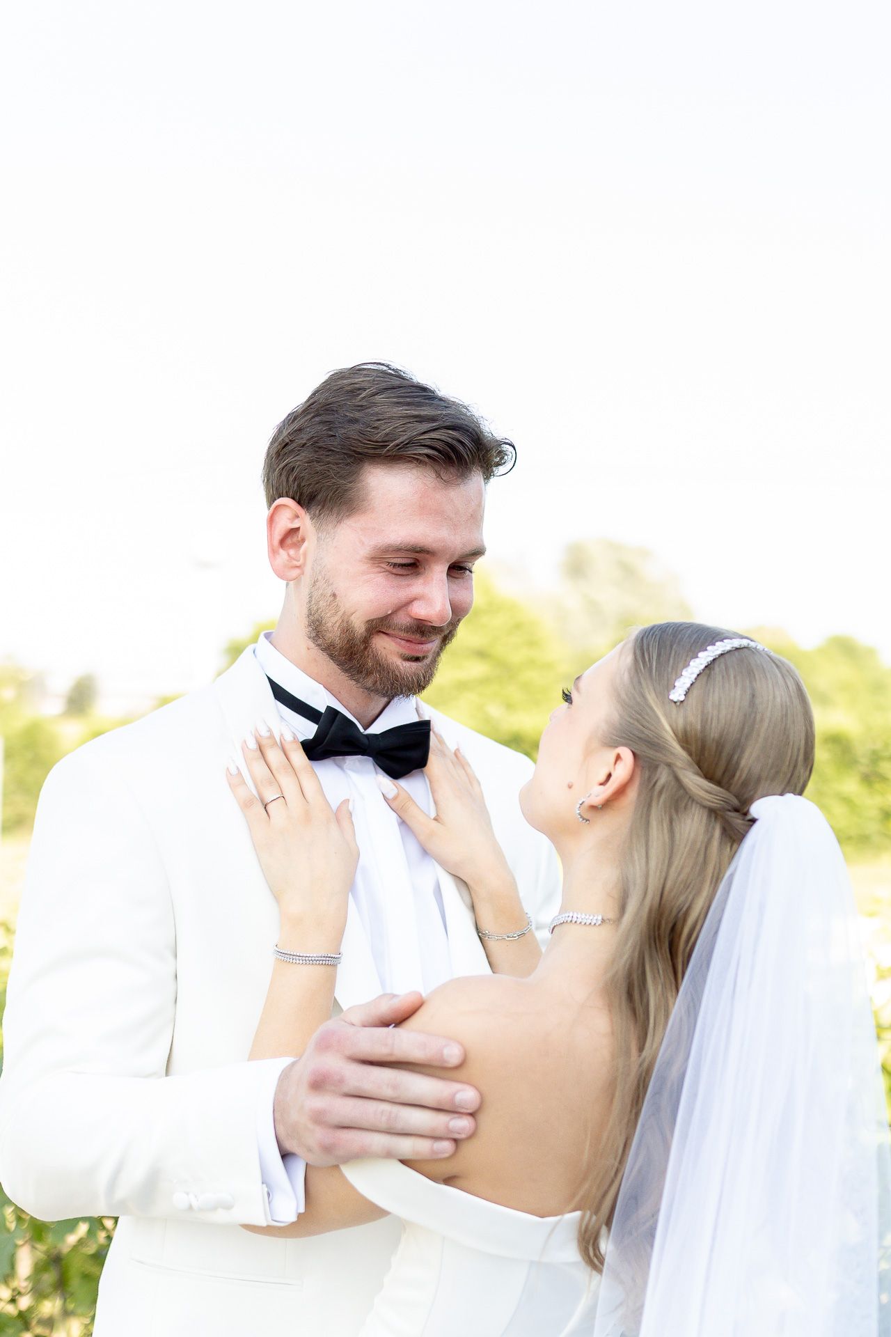 A romantic wedding couple shares intimate moments in an outdoor garden setting.