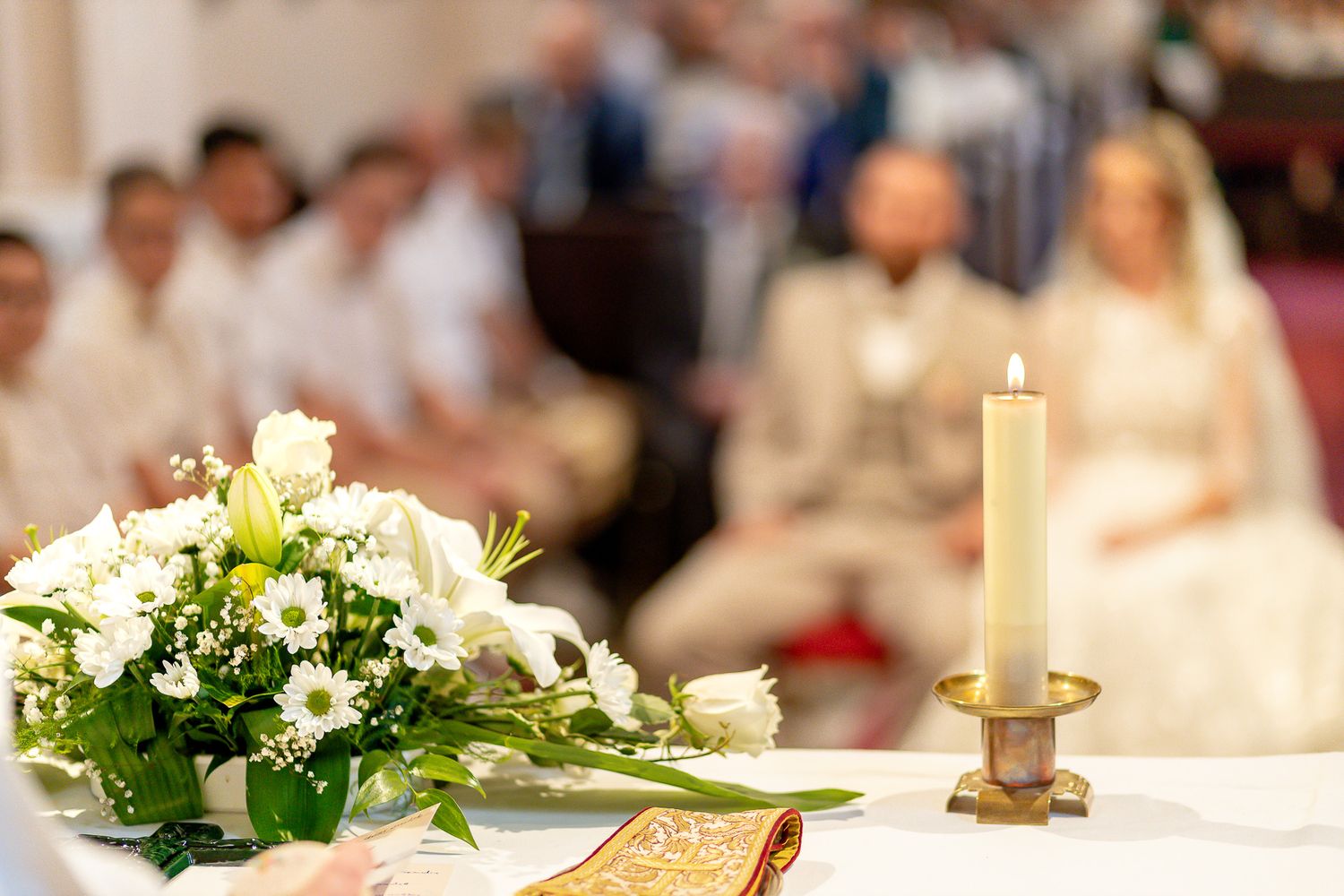 A formal wedding reception table setting with white flowers, candles and elegant decor in a banquet hall.