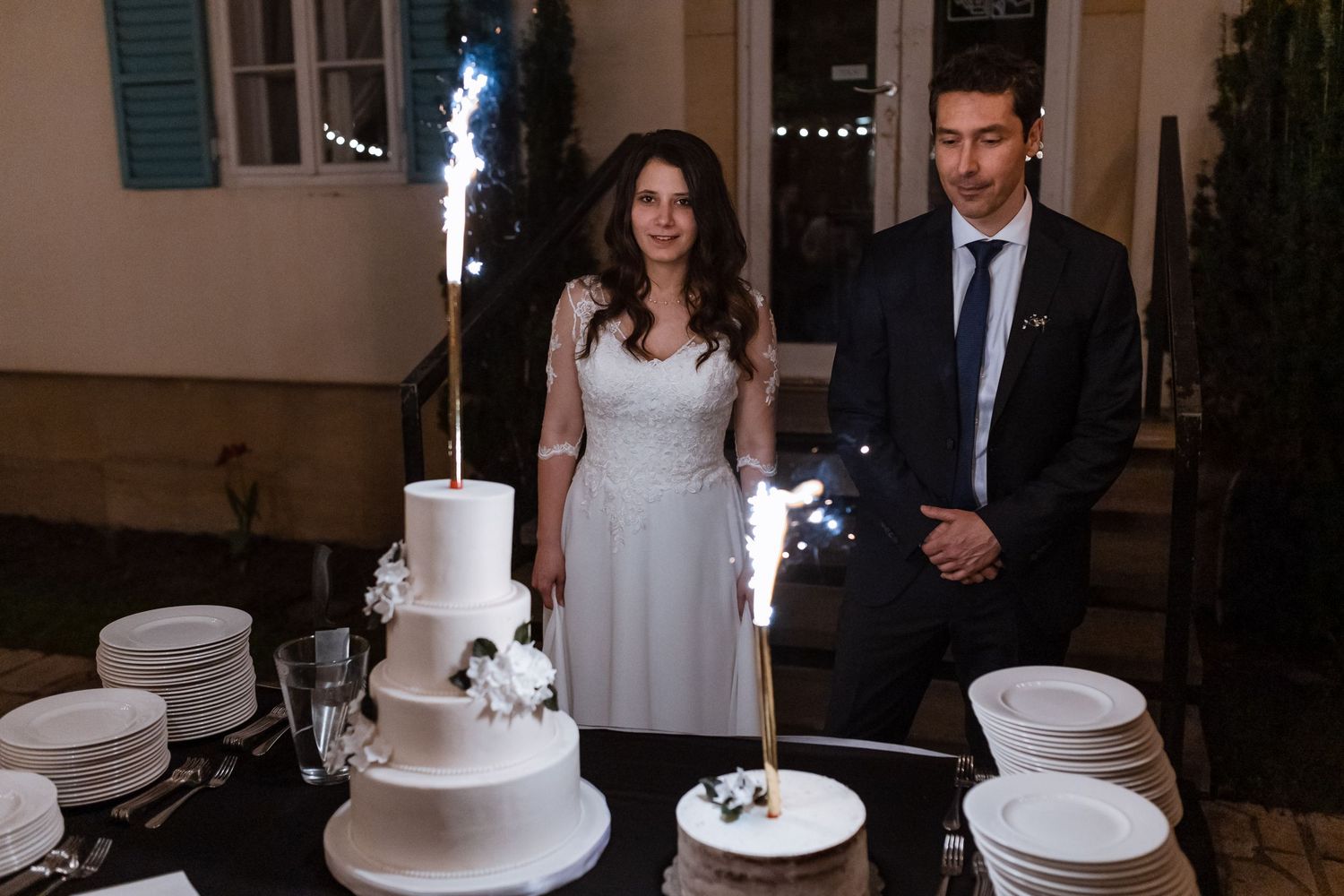 A wedding cake cutting sequence shown in multiple connected photos with white tiered cakes and formal attire.