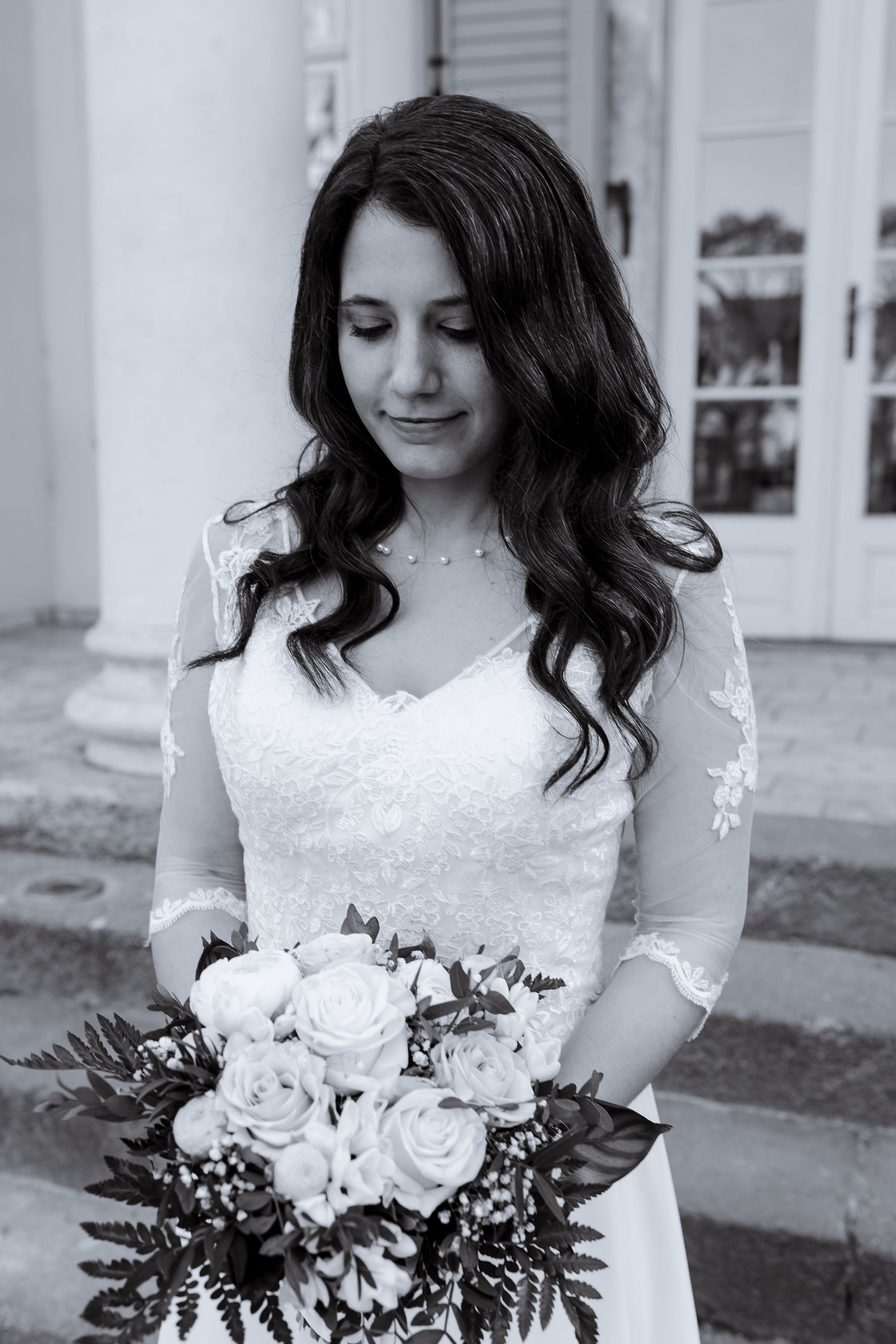 Black and white wedding photo series showing a bride in lace dress holding a romantic bouquet of roses and greenery.