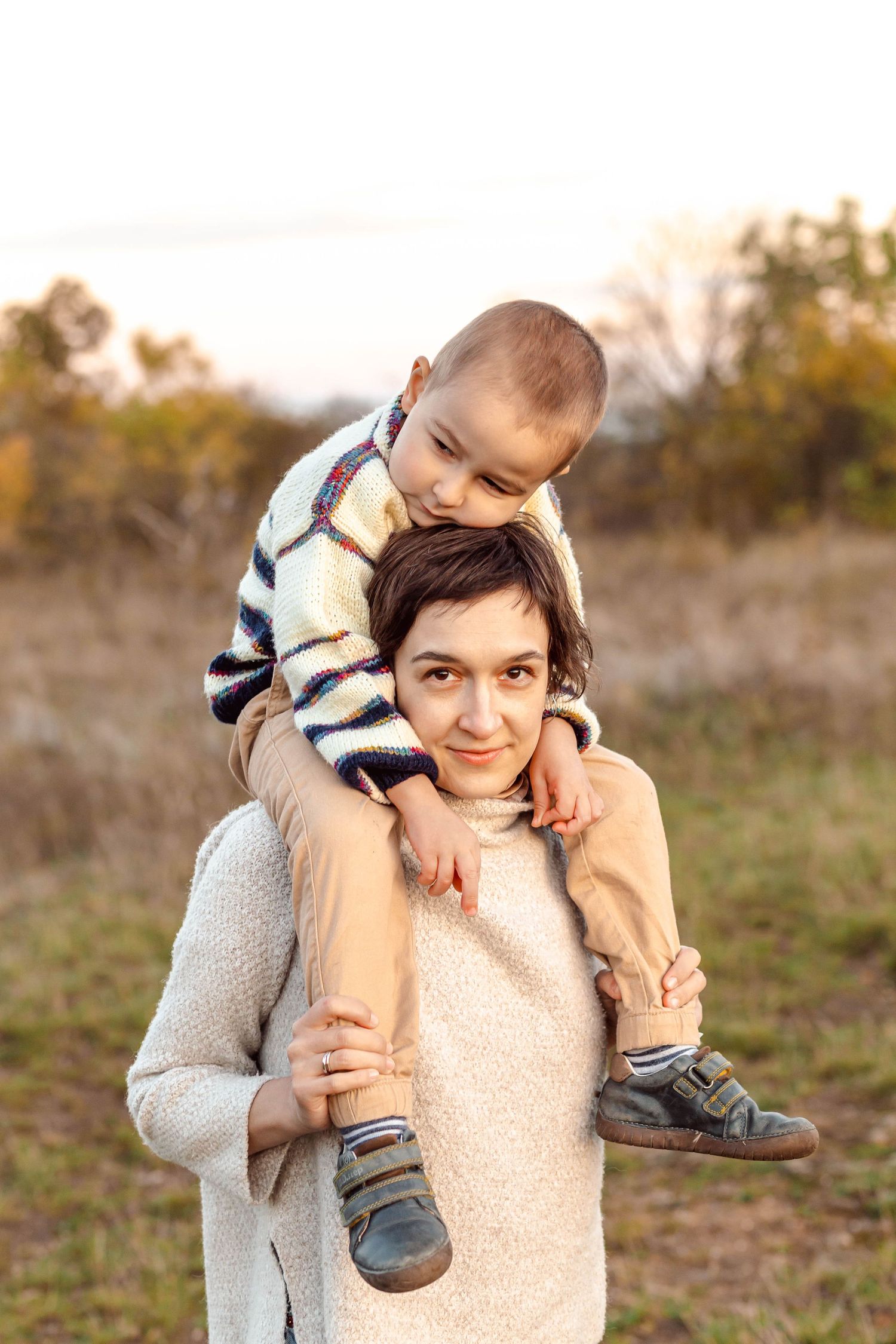 Playful moment captured between parent and child outdoors in natural setting.