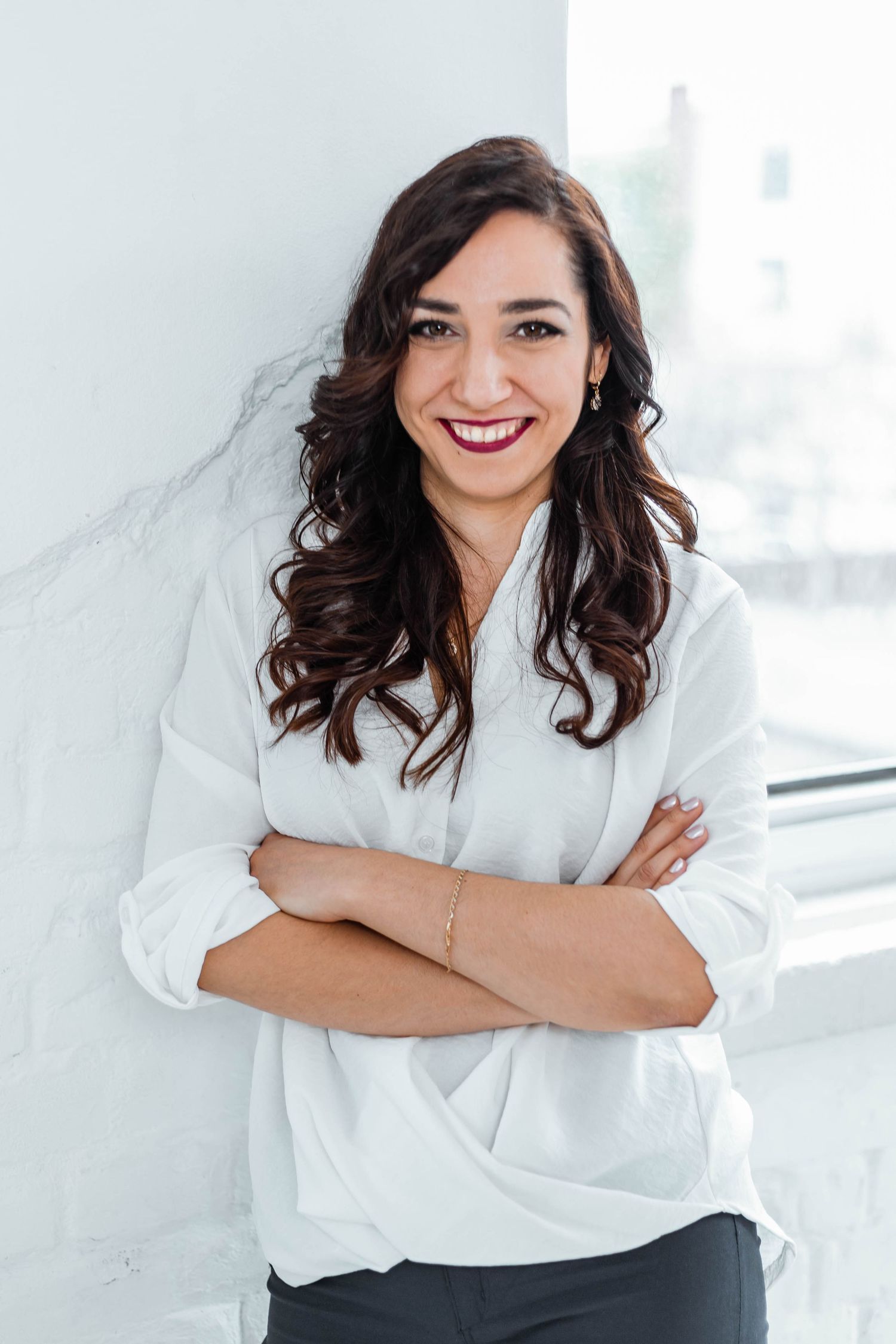 Professional portrait in crisp white button-down shirt against bright white background.