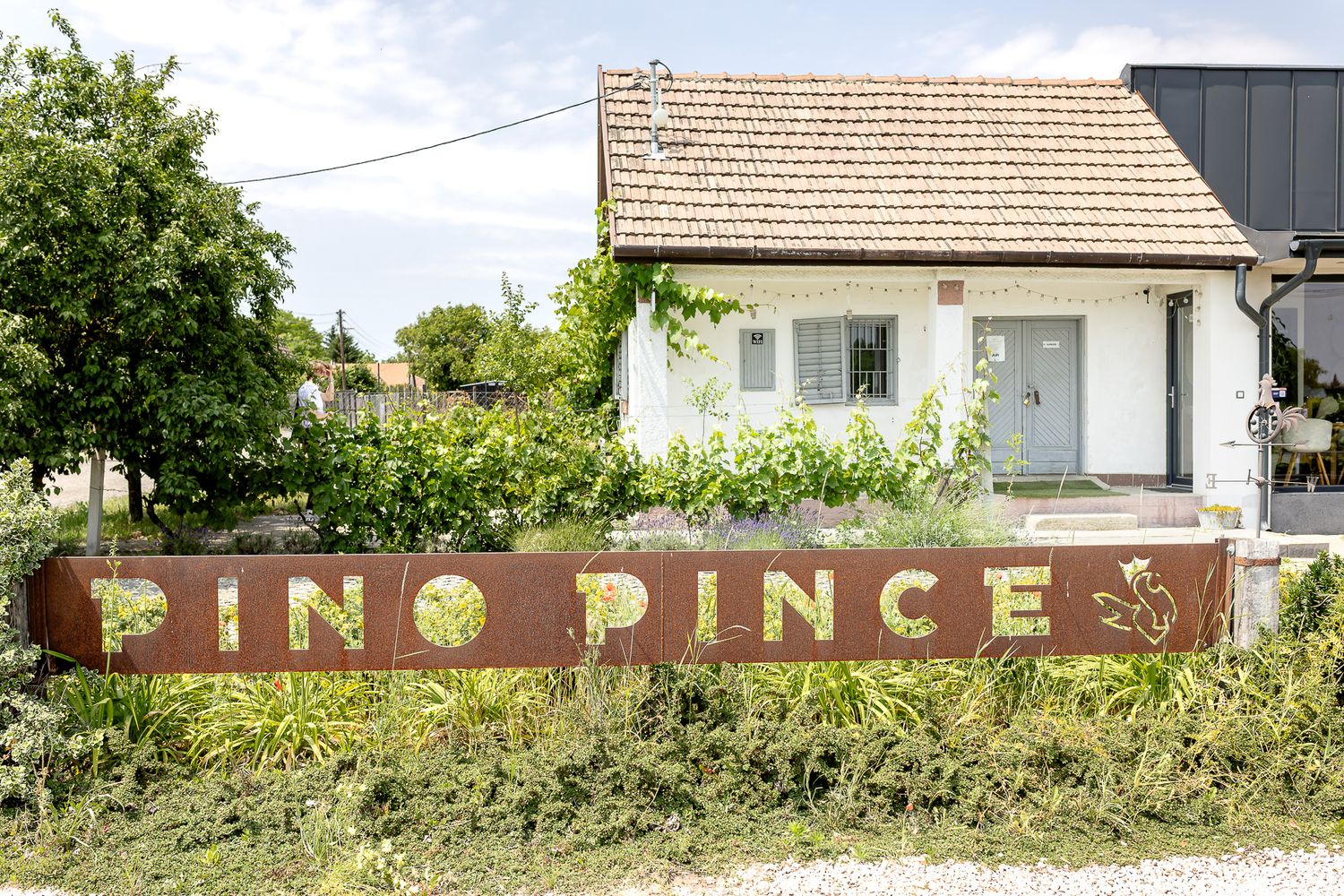 Rustic brown wooden fence with vintage signage visible against greenery and buildings in the background.
