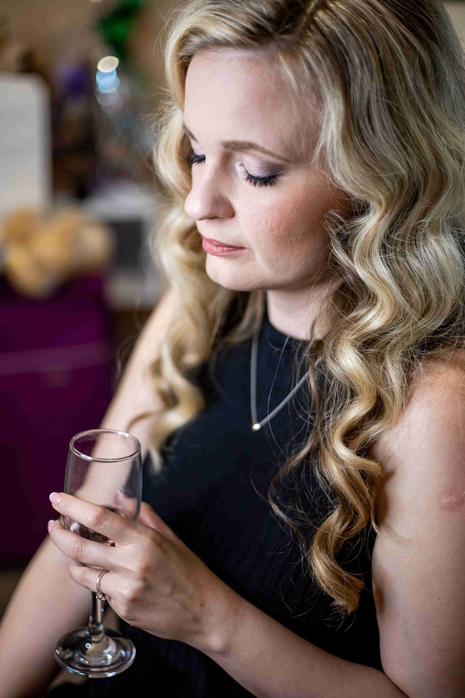 A sequence of profile shots showing a woman with wavy blonde hair sipping from a glass in a dimly lit setting.