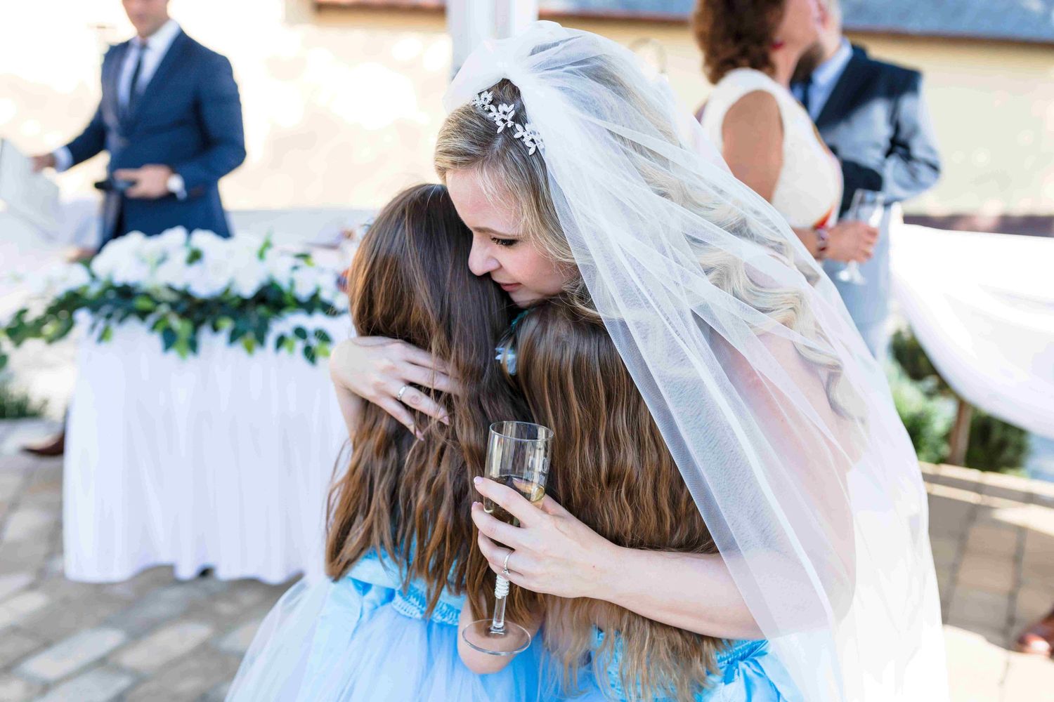 A series of wedding photos showing tender moments between the bride and loved ones during an outdoor celebration.