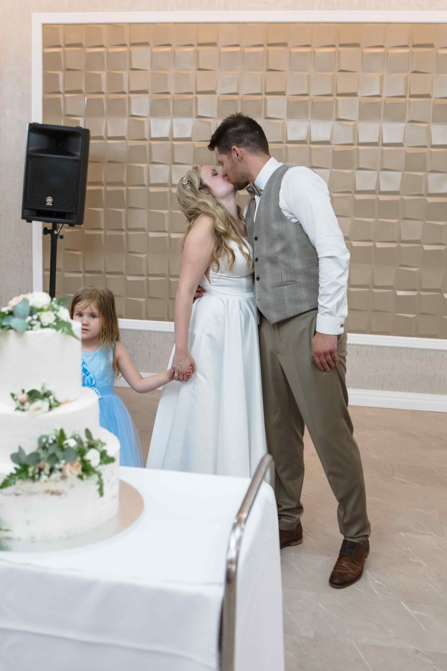 A sweet sequence of wedding photos shows a flower girl in blue dress interacting with the bride and groom during celebrations.