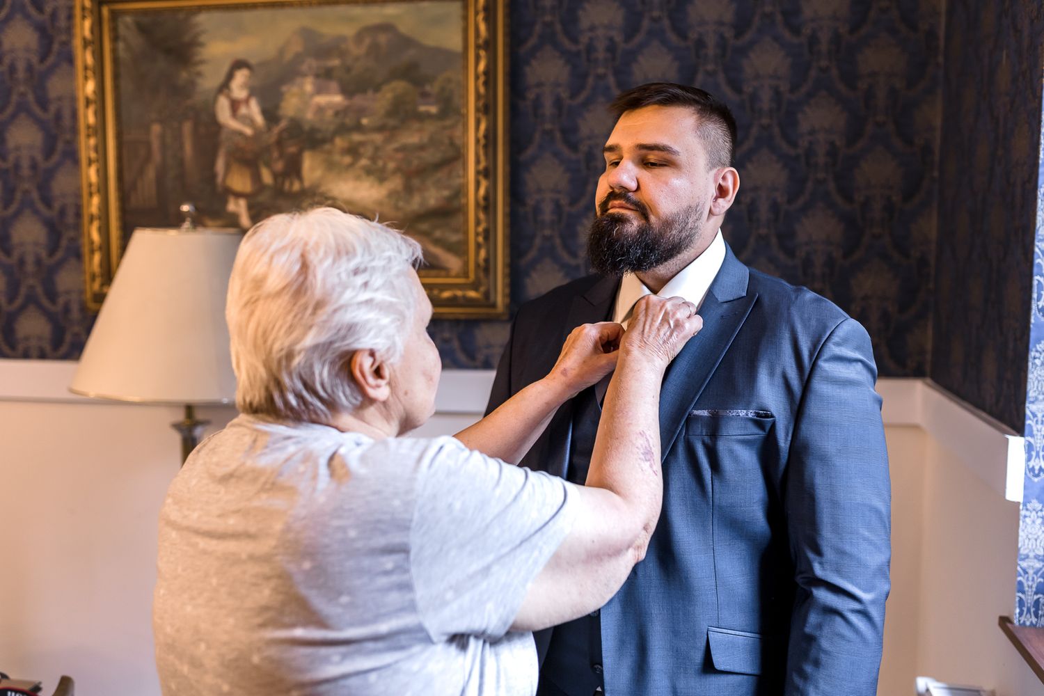 Four sequential photos show a touching moment between an elderly person in white and someone in a blue suit.