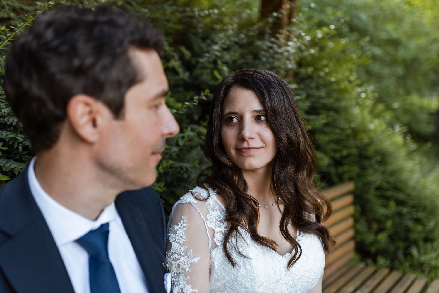 A happy couple shares intimate moments in a lush garden setting during their wedding photo session.