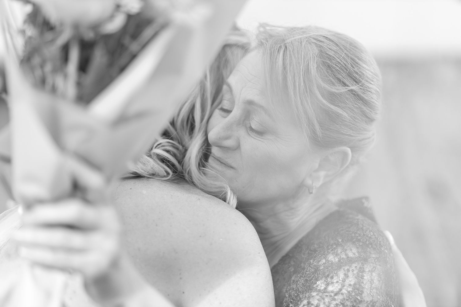 A series of intimate black and white wedding moments showing emotional embraces and celebrations.