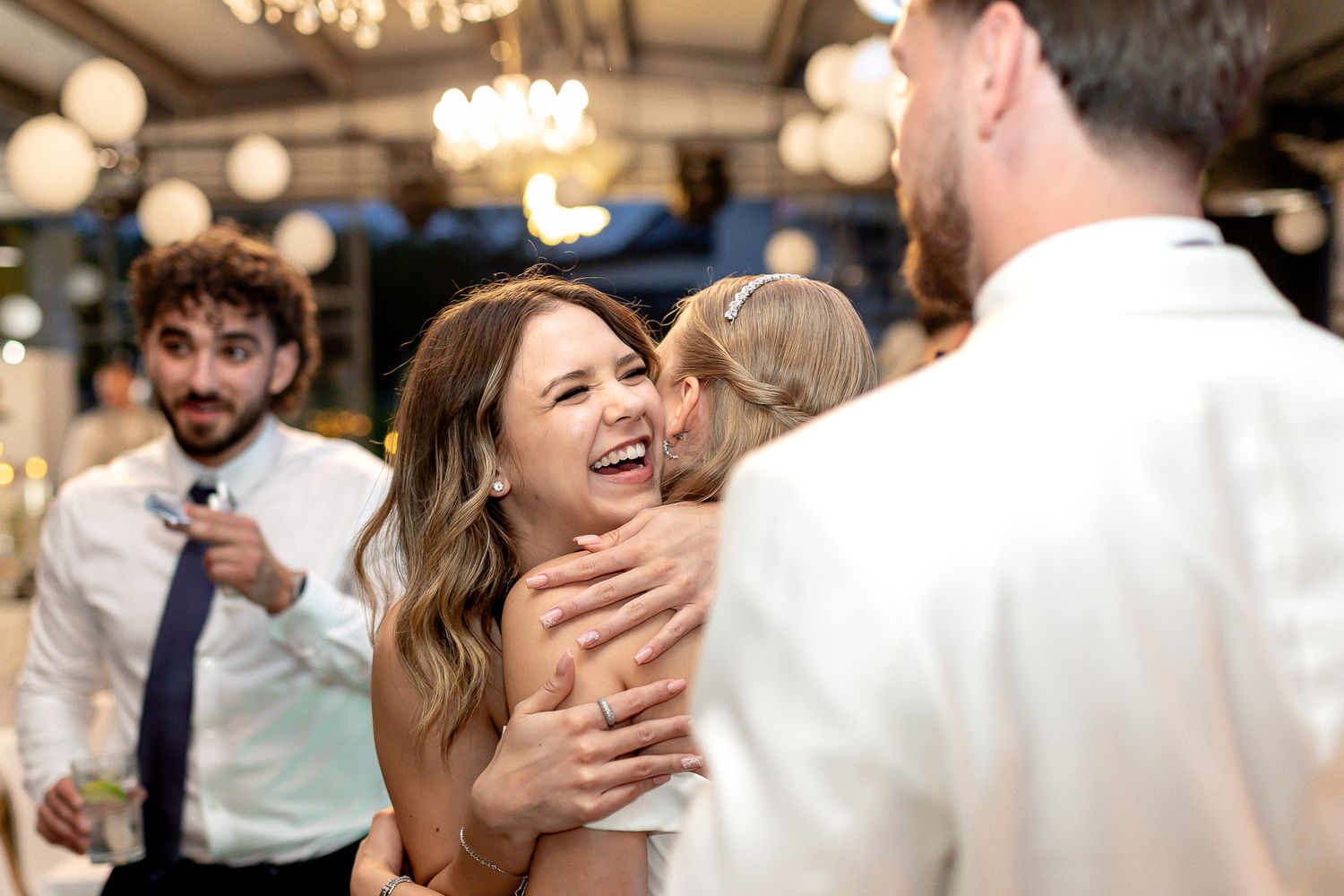 Wedding celebration candid moments captured under elegant reception lighting.
