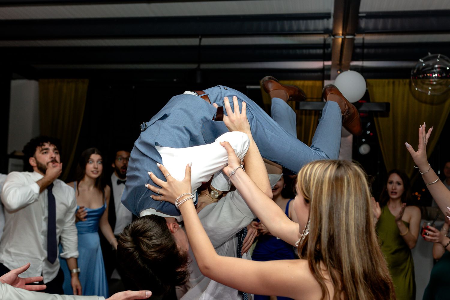 Energetic dance party with guests enjoying themselves at an indoor wedding celebration.