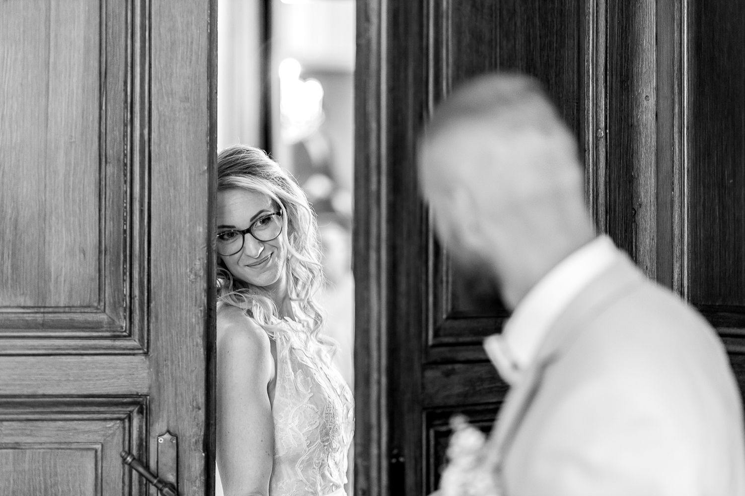 A black and white wedding photo series showing intimate moments between a couple in a traditional church setting.