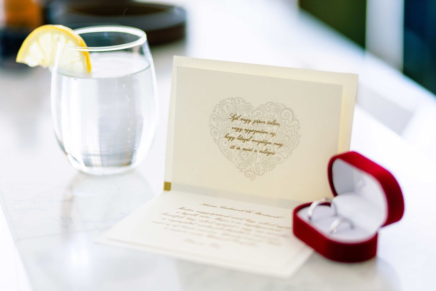 Wedding invitation suite with elegant calligraphy and a red velvet ring box.