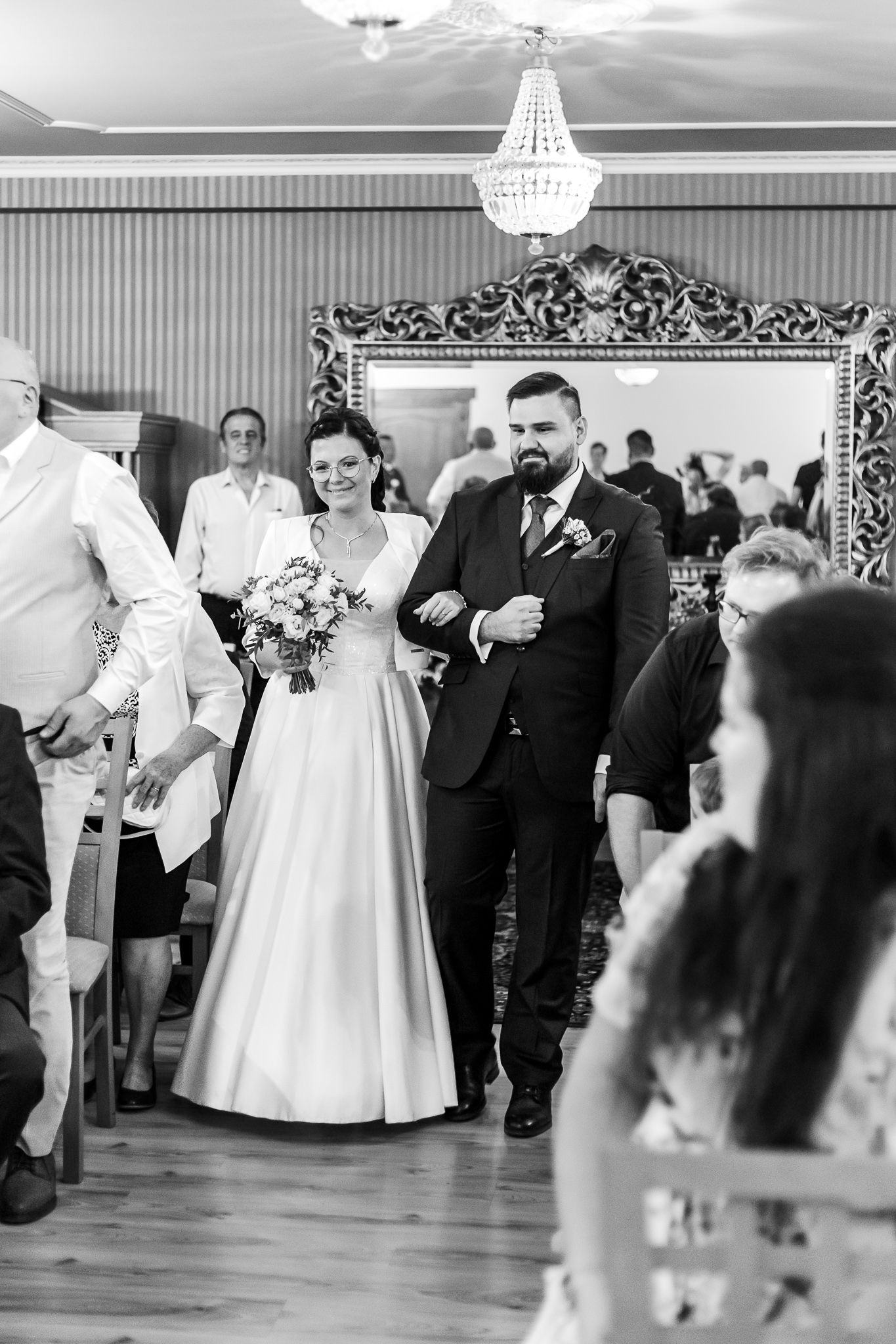 A wedding reception dance sequence showing guests celebrating in an elegant ballroom with a chandelier.