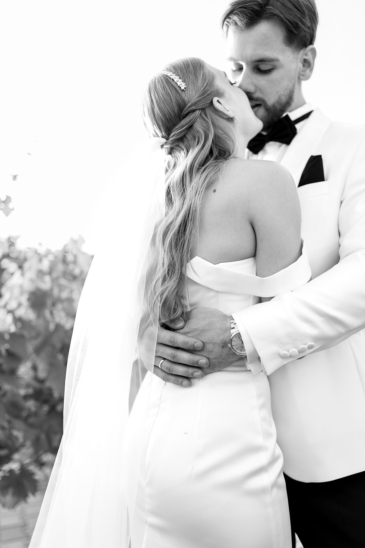 Black and white wedding portrait captures tender moments between bride and groom.