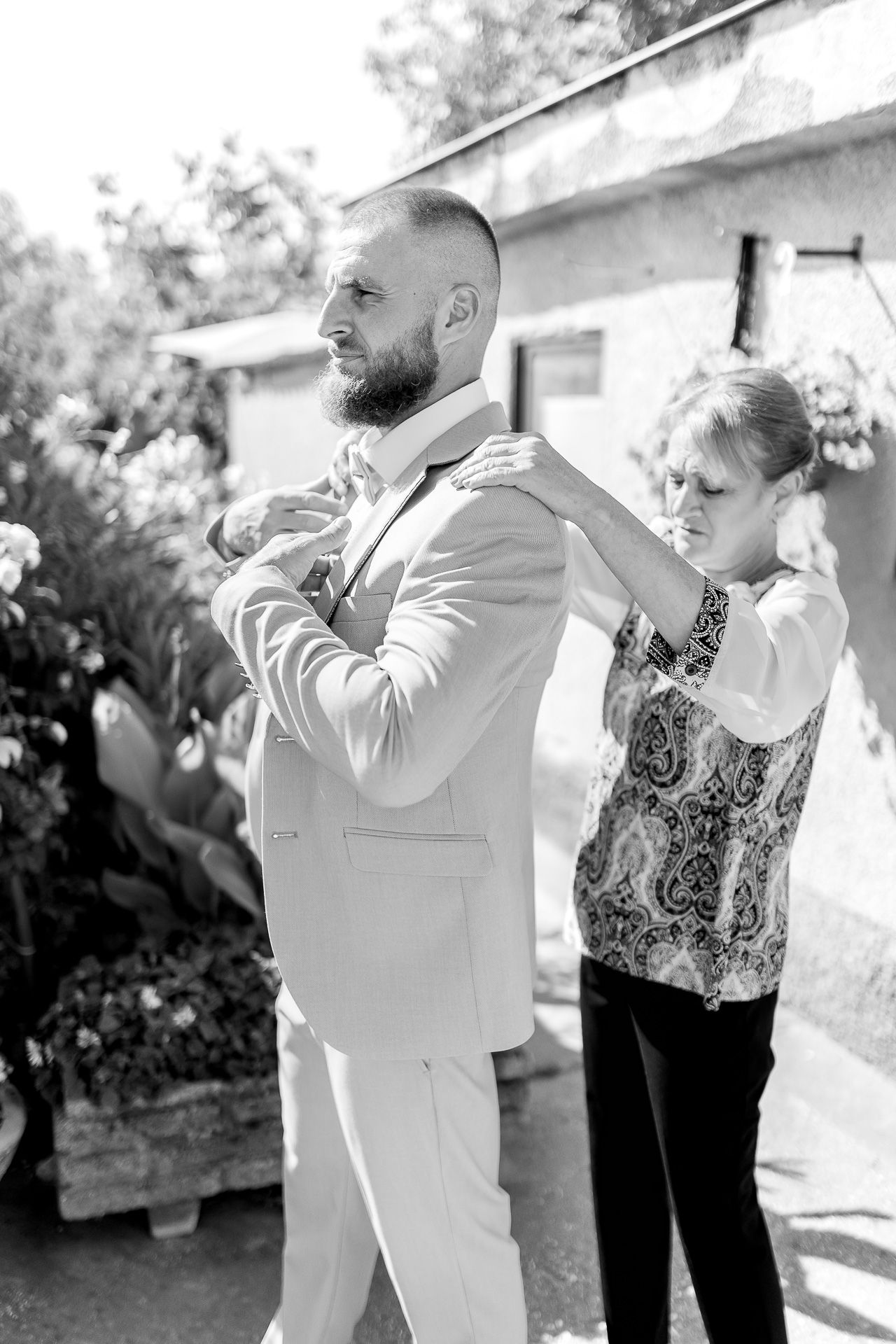 A sequence of black and white photos showing two people sharing an emotional embrace outdoors.