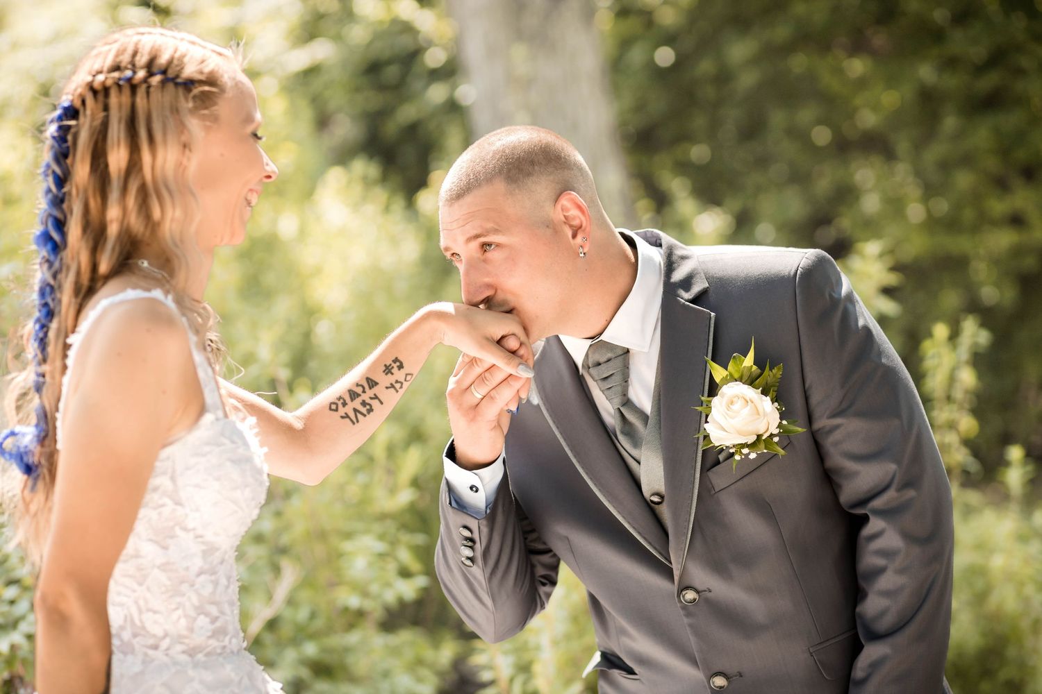 A couple shares a tender moment during their outdoor wedding ceremony in a garden setting.