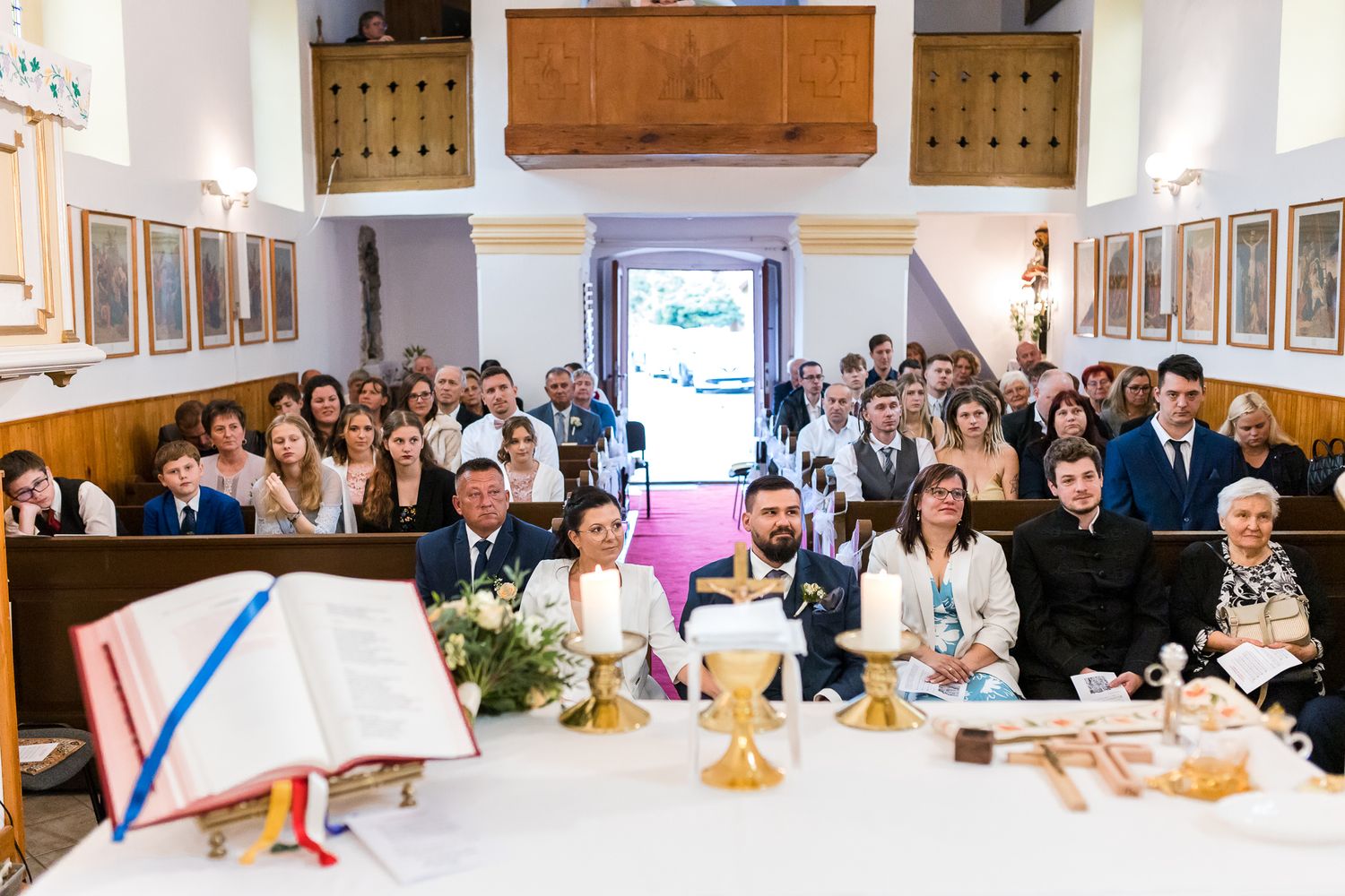 A panoramic view of a formal event with guests seated at long tables in a bright banquet hall.