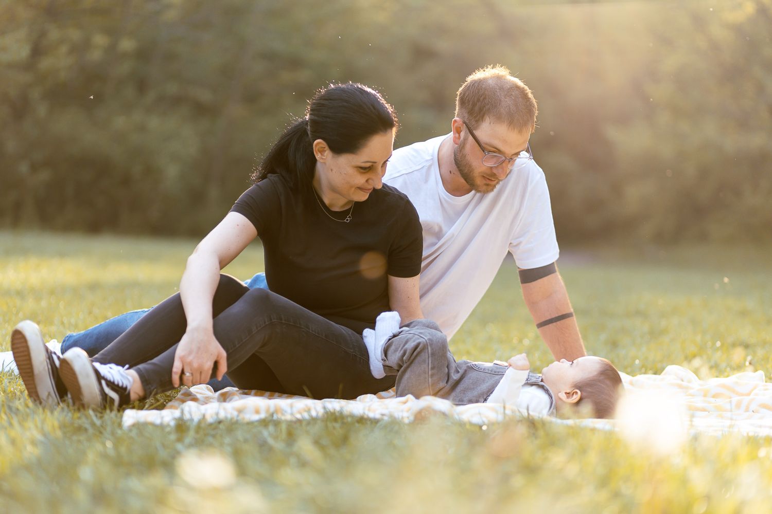 Candid family photo session on grass during sunset.