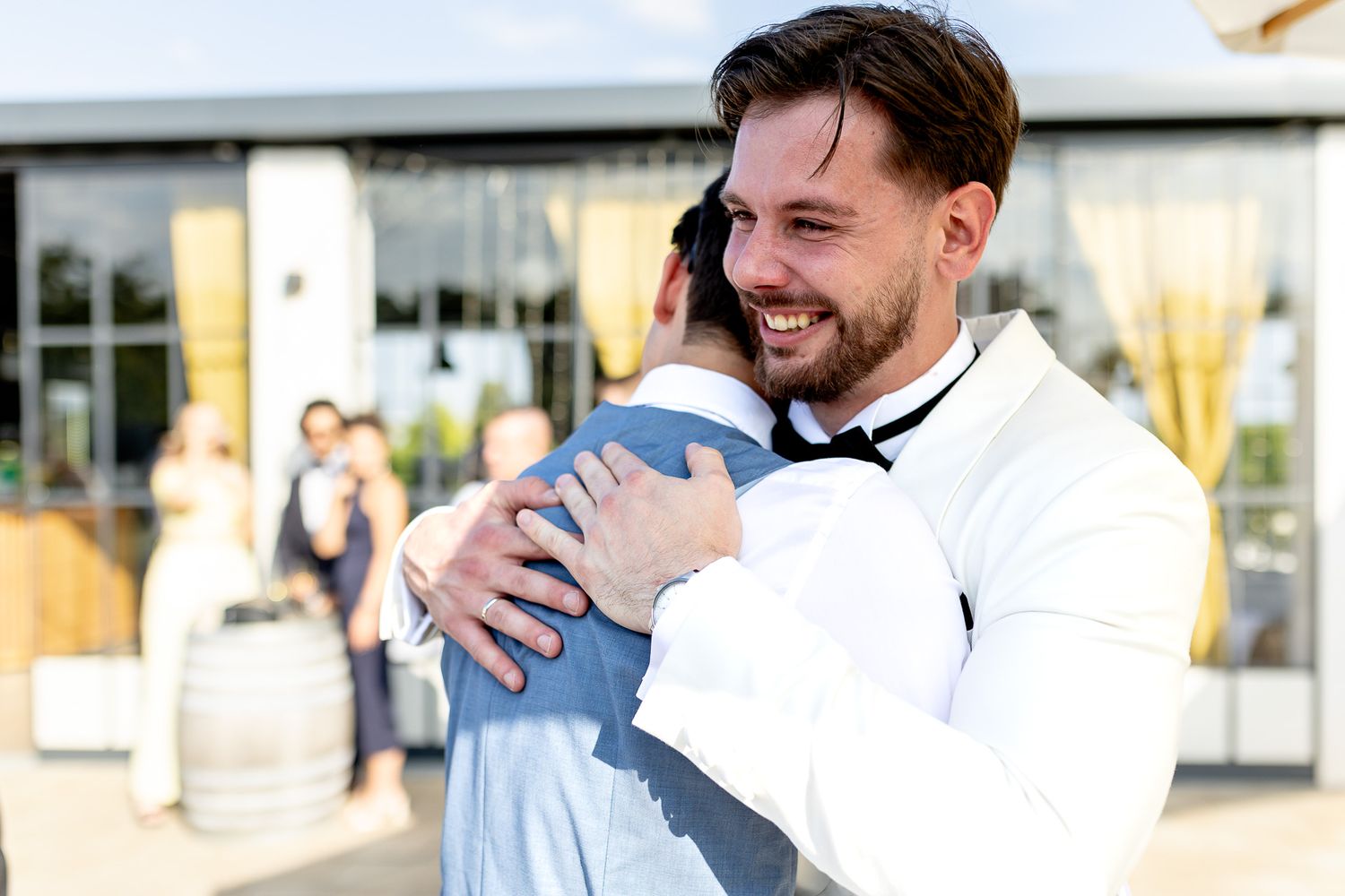 Wedding guests mingle and celebrate during outdoor reception.