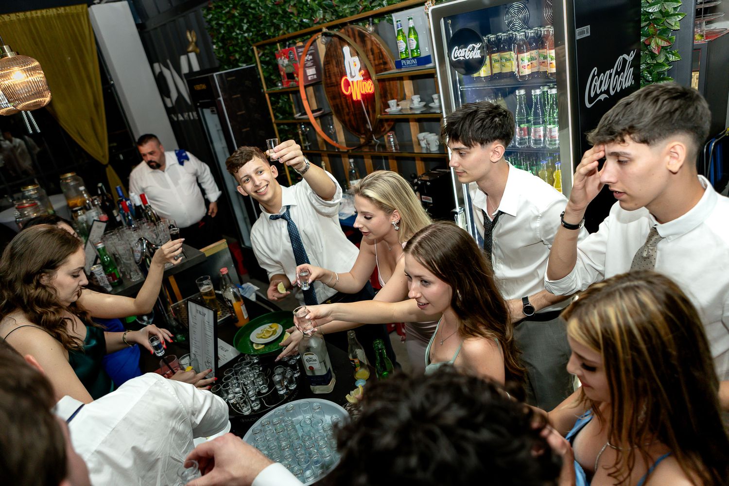 Wedding celebration showing guests dancing and mingling in a venue with bar area.