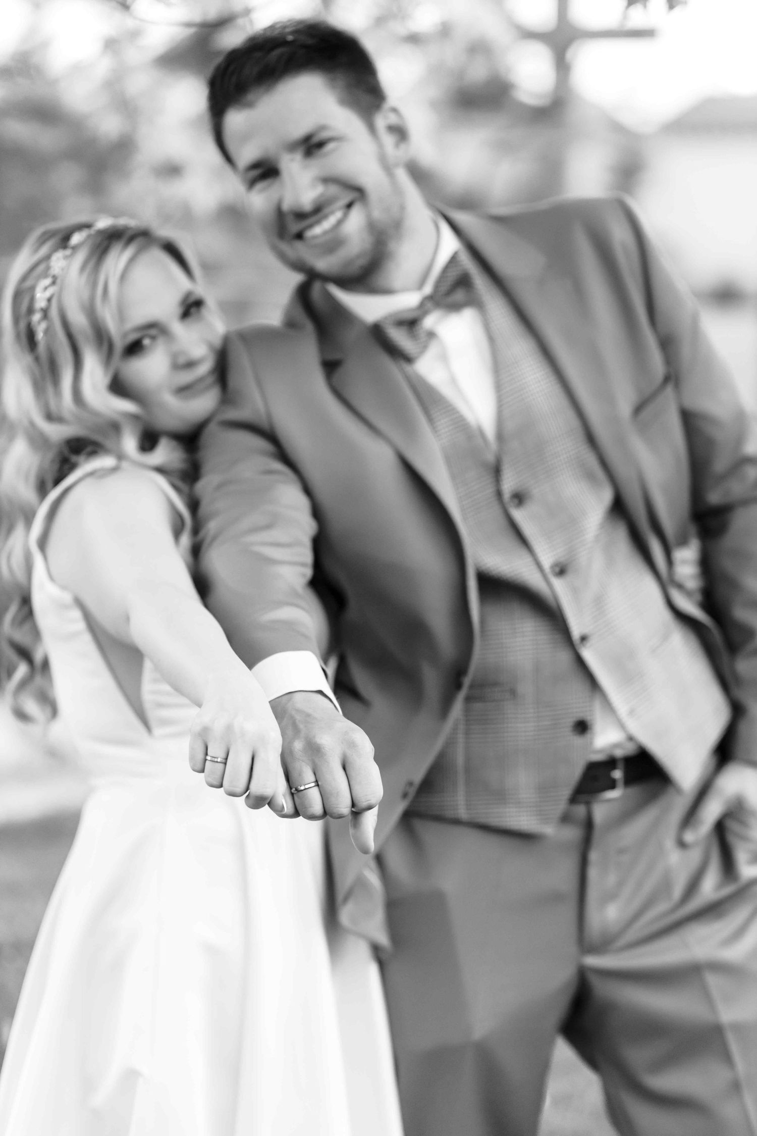 Black and white wedding photos showing happy couple laughing and embracing in formal attire.