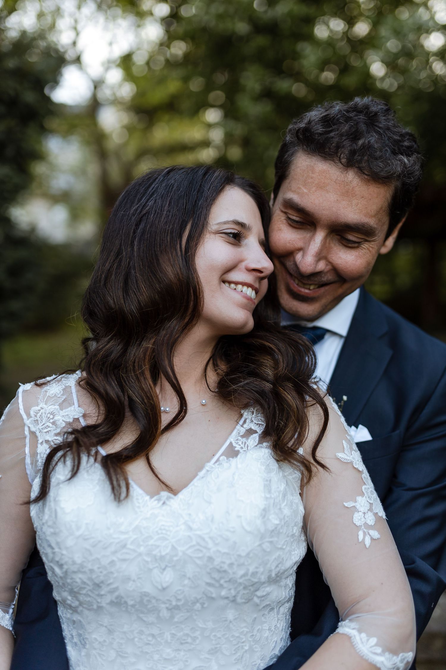 A couple in wedding attire share intimate moments together outdoors in a series of romantic portrait photographs.