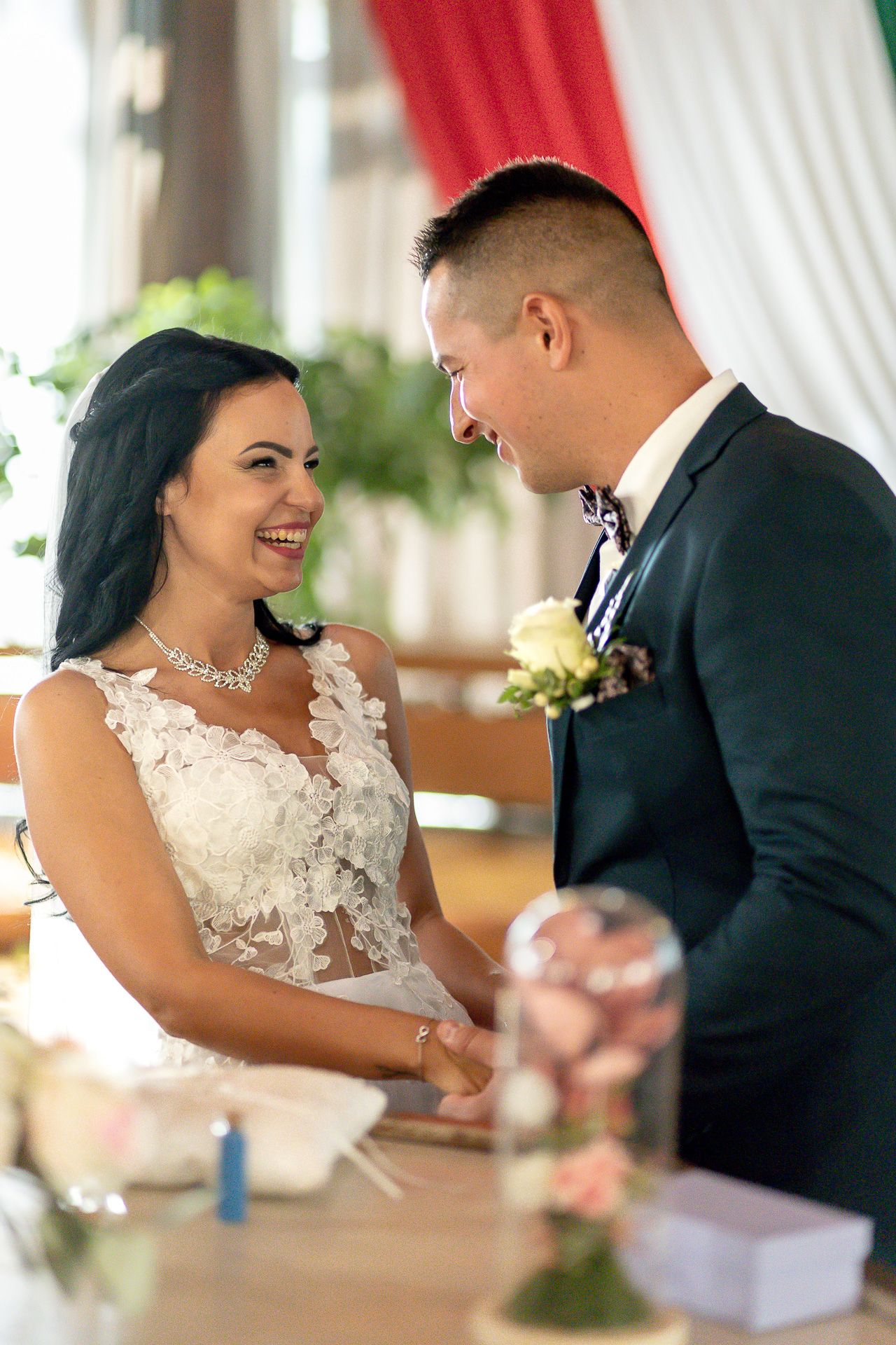 Joyful couple shares candid laughing moments during their wedding reception celebration.