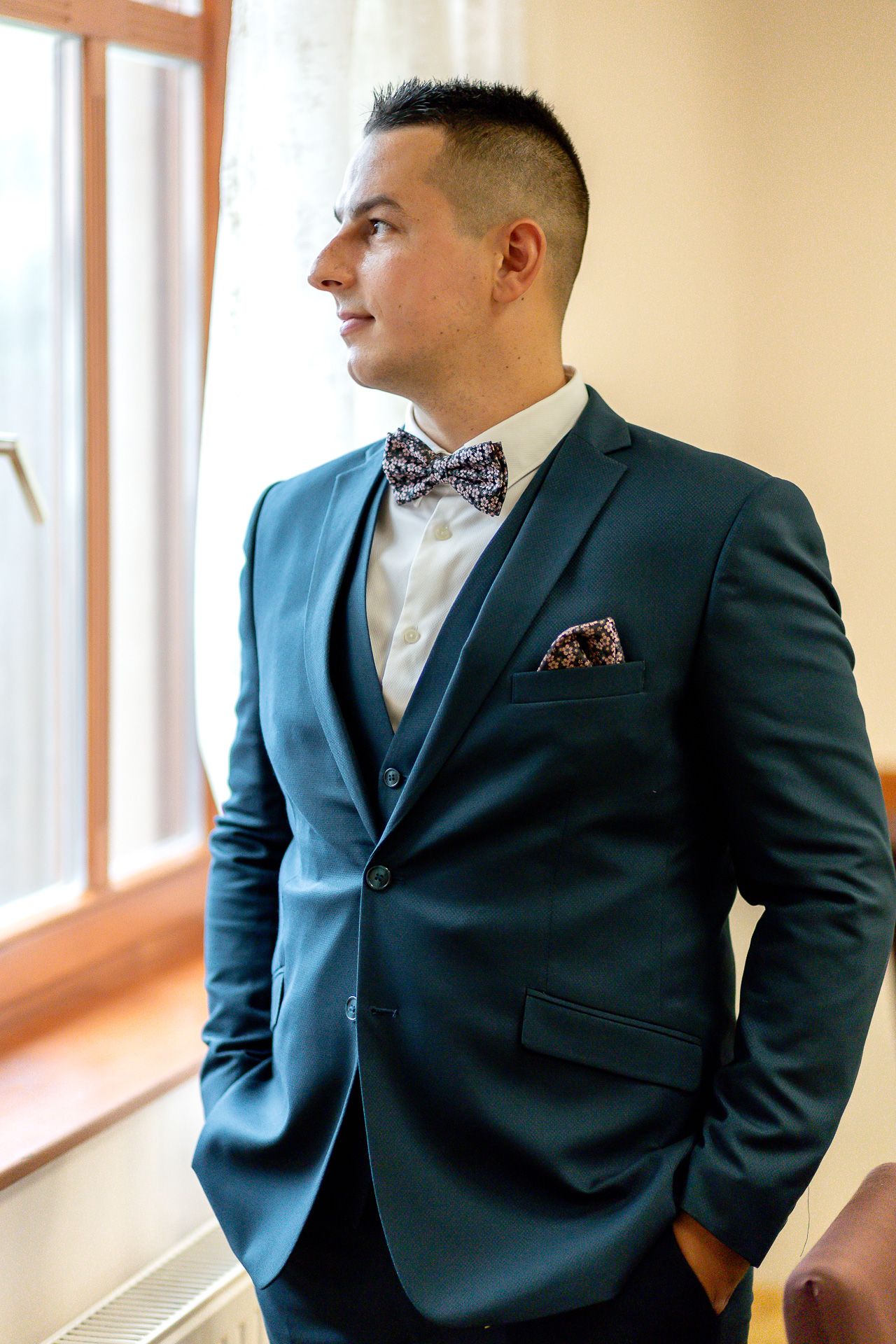 Professional portrait series showing a suited figure in navy blue against a bright hallway background.