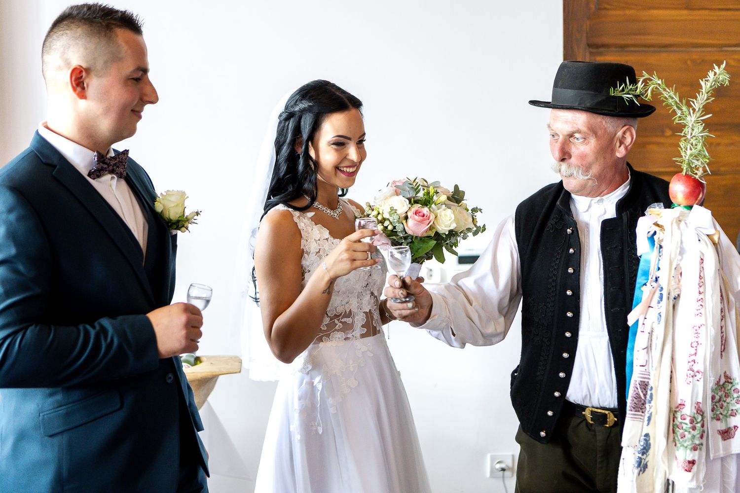 A couple shares an intimate moment during their wedding ceremony while exchanging rings at an outdoor venue.