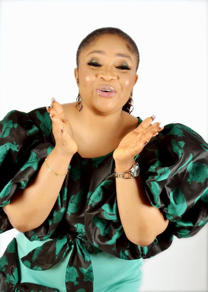 Joyful pose in green and black patterned dress with statement sleeves.