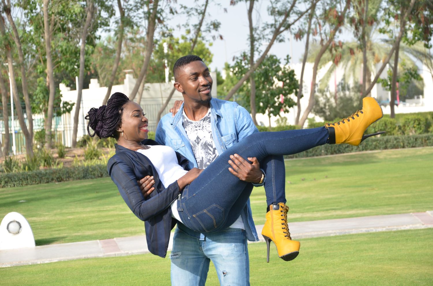 People playfully posing in park setting with palm trees in background.