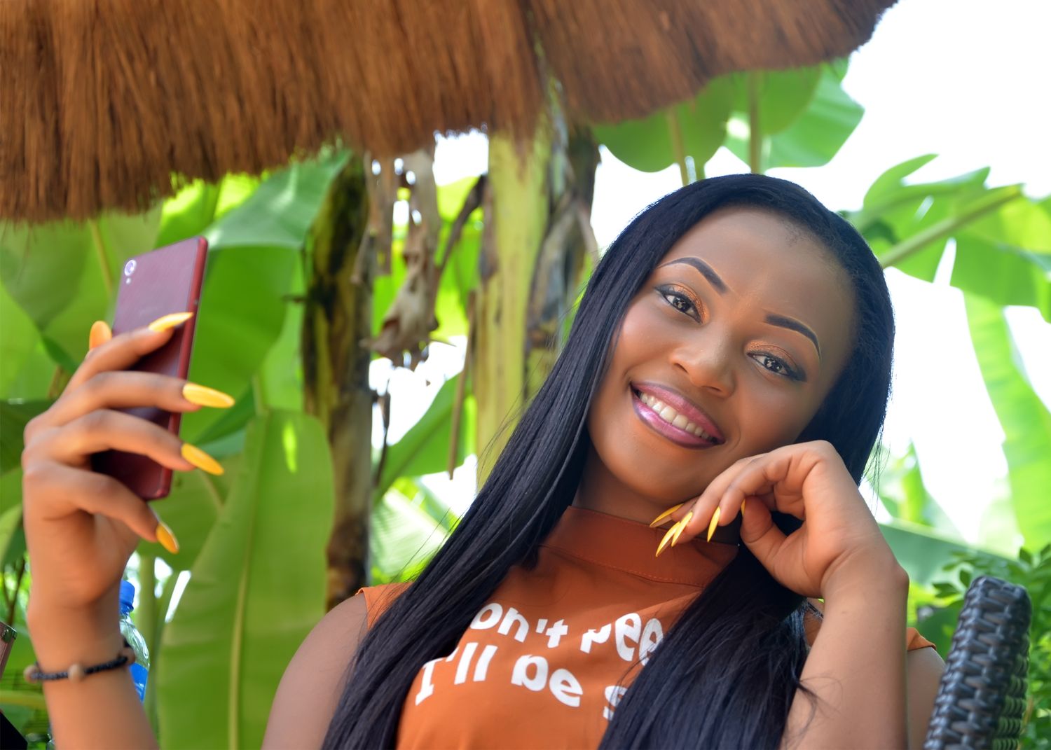 A casual selfie moment captured among tropical palm leaves and greenery.