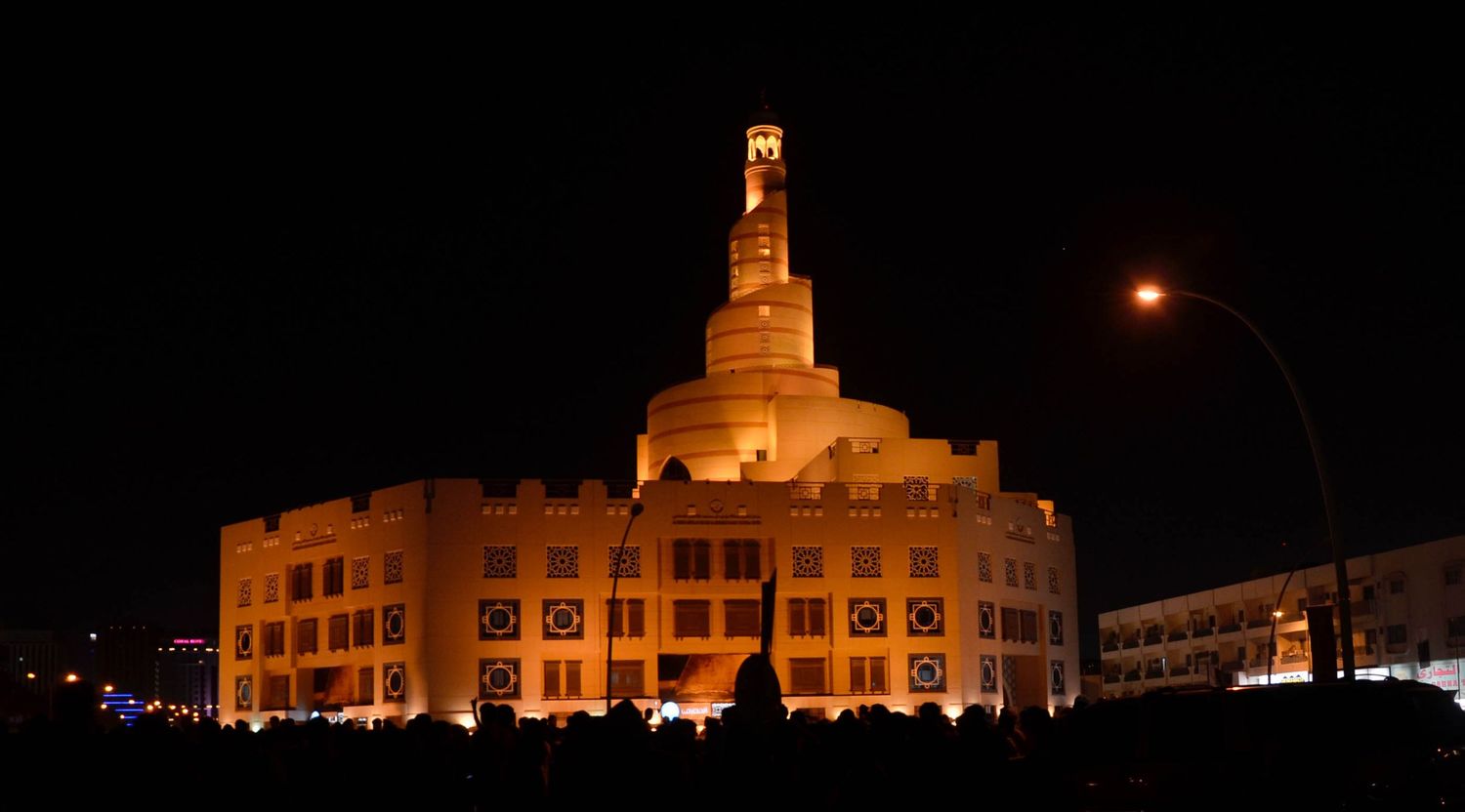 Illuminated Islamic Cultural Center of Qatar glowing beautifully against the night sky.