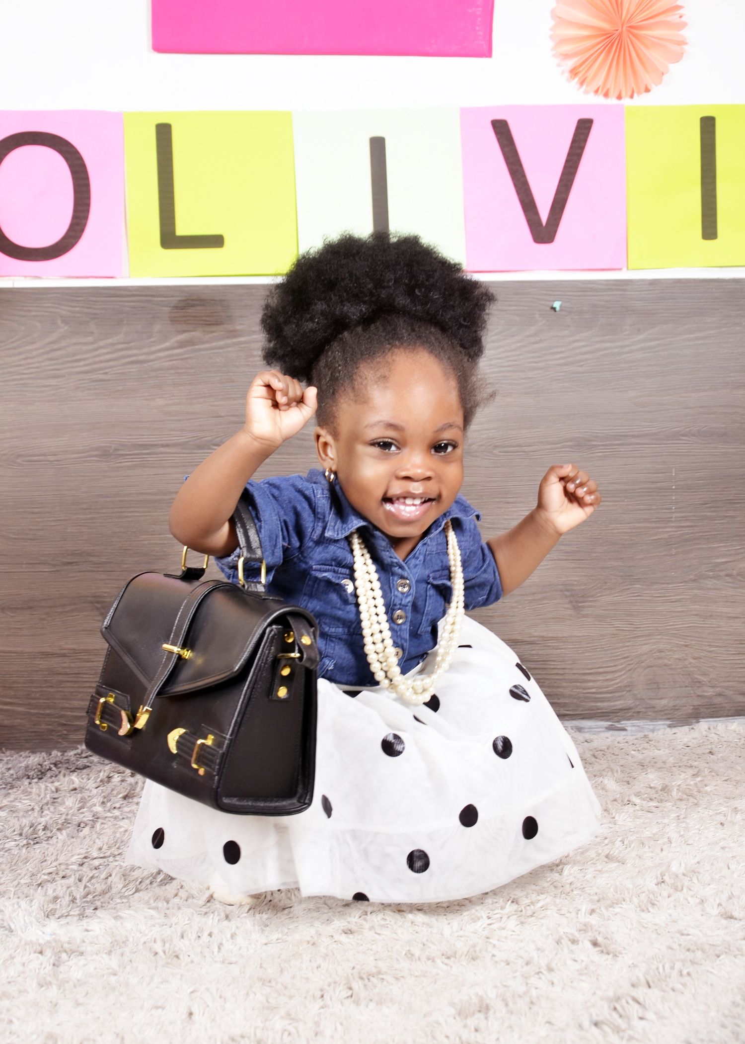 A stylish outfit featuring a denim top, polka dot skirt, and black handbag.