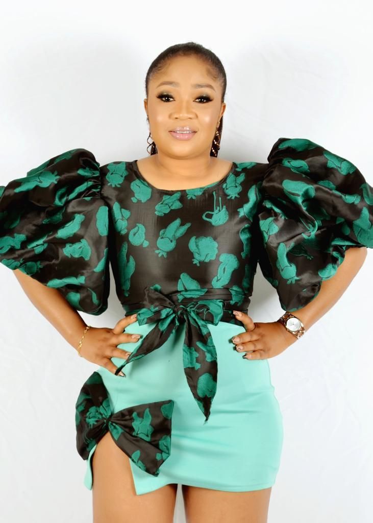 Elegant dress featuring green and black floral pattern with dramatic puff sleeves.