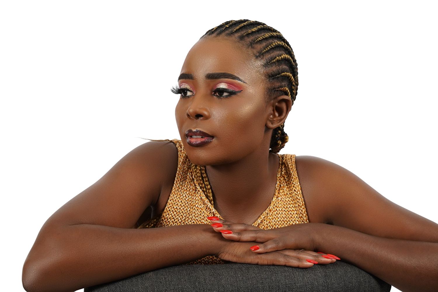 Beauty portrait with gold metallic top and braided hairstyle against neutral background.