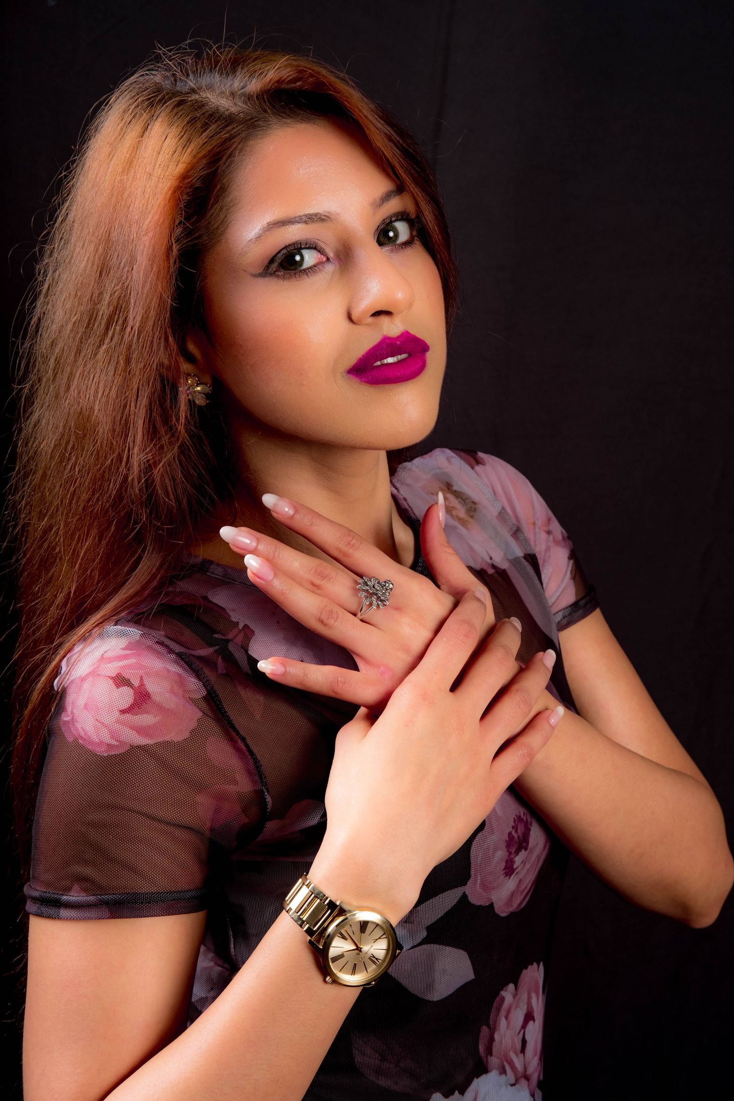 Studio portraits in floral pink top with gold watch showing various posed expressions.