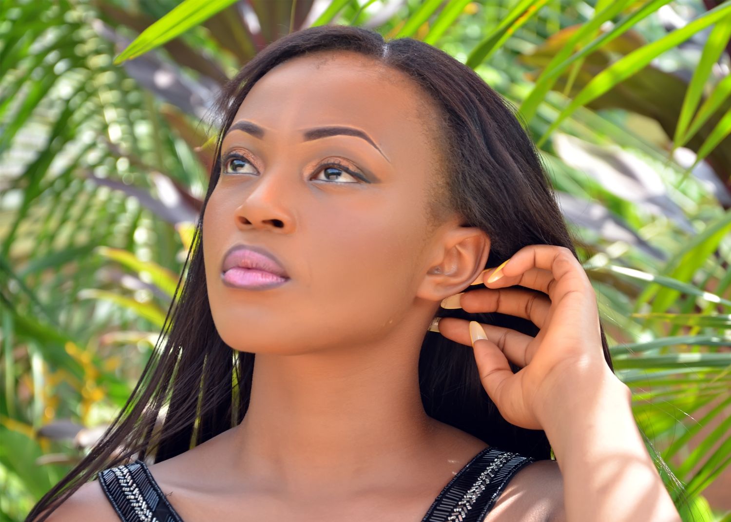 Artistic portrait series with dramatic angles against tropical plant background.