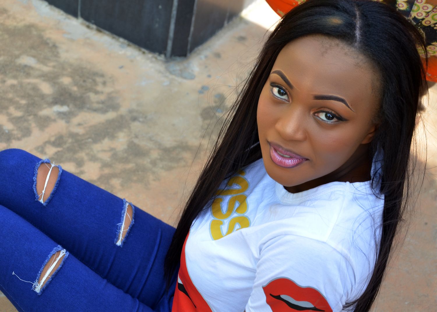 Woman in white and blue sporty attire poses casually in outdoor setting.