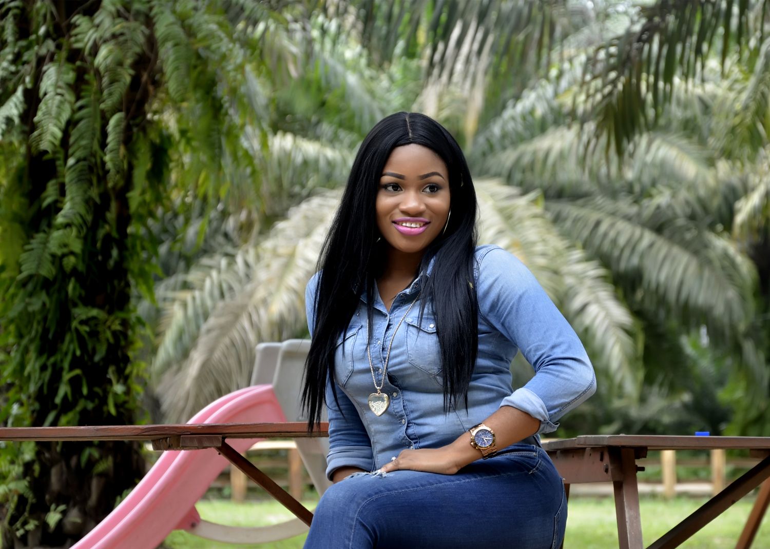 Casual outdoor photo session featuring denim and blue attire against a backdrop of tropical palm trees.