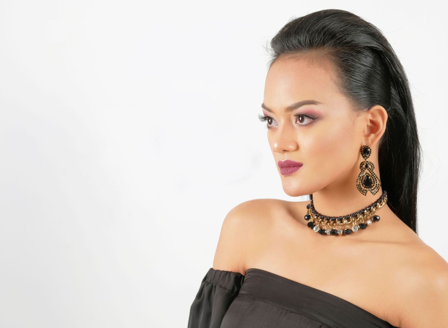 Profile shots showcasing statement jewelry and off-shoulder styling against white backdrop.