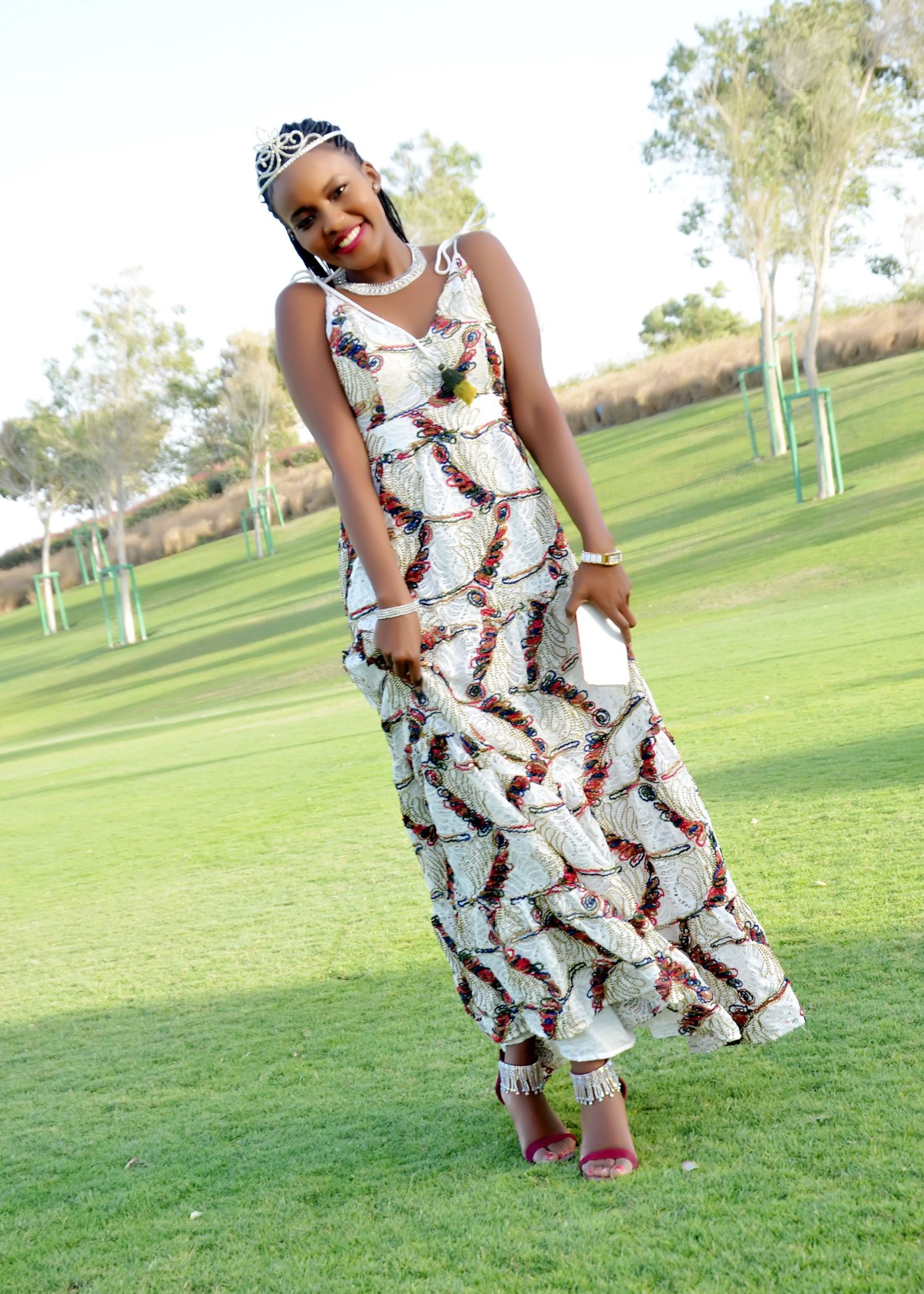 A flowing white and brown patterned dress catches the breeze on a sunny golf course.