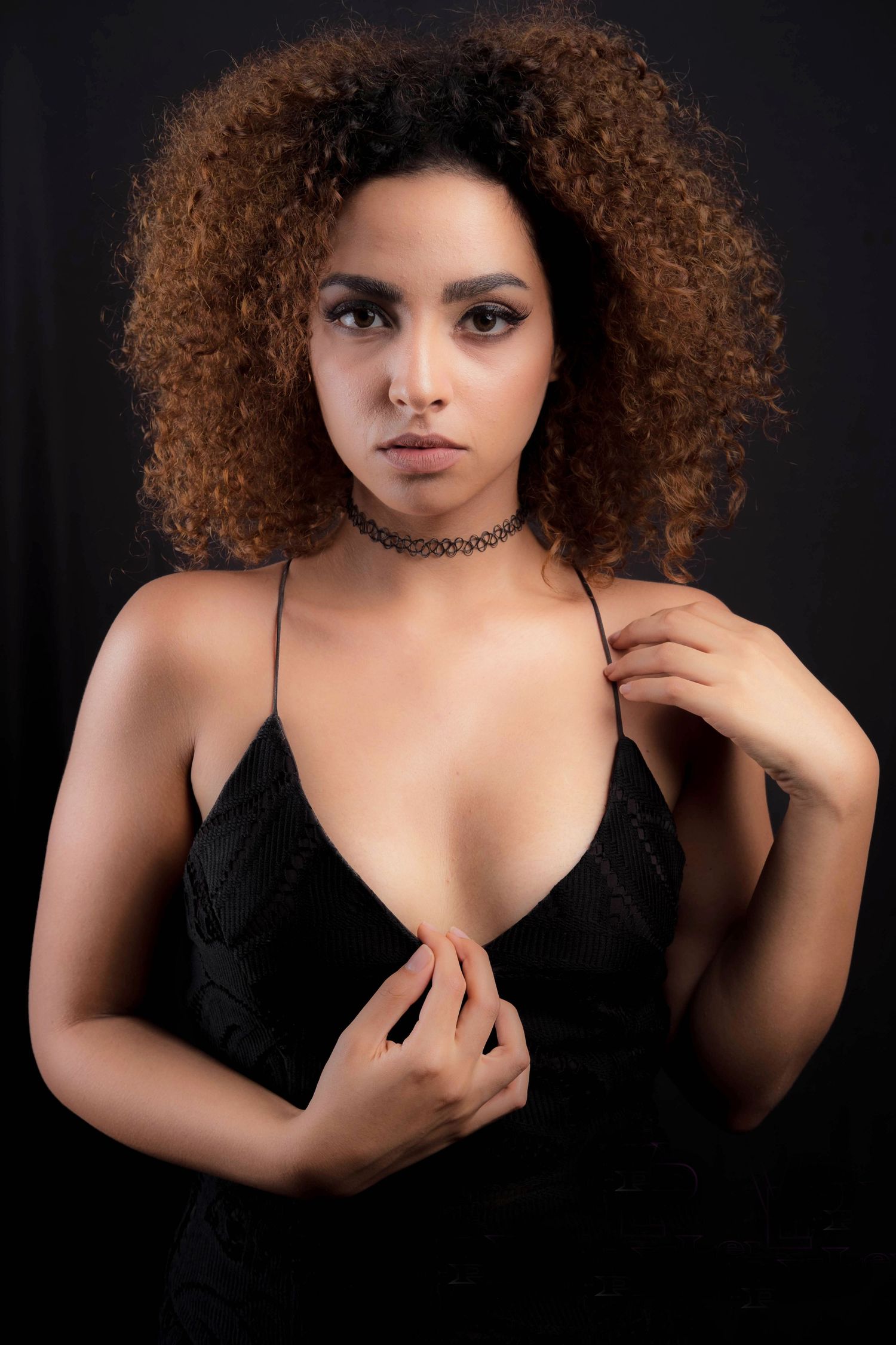 Artistic dark portrait series featuring curly hair and black top with dramatic shadows.