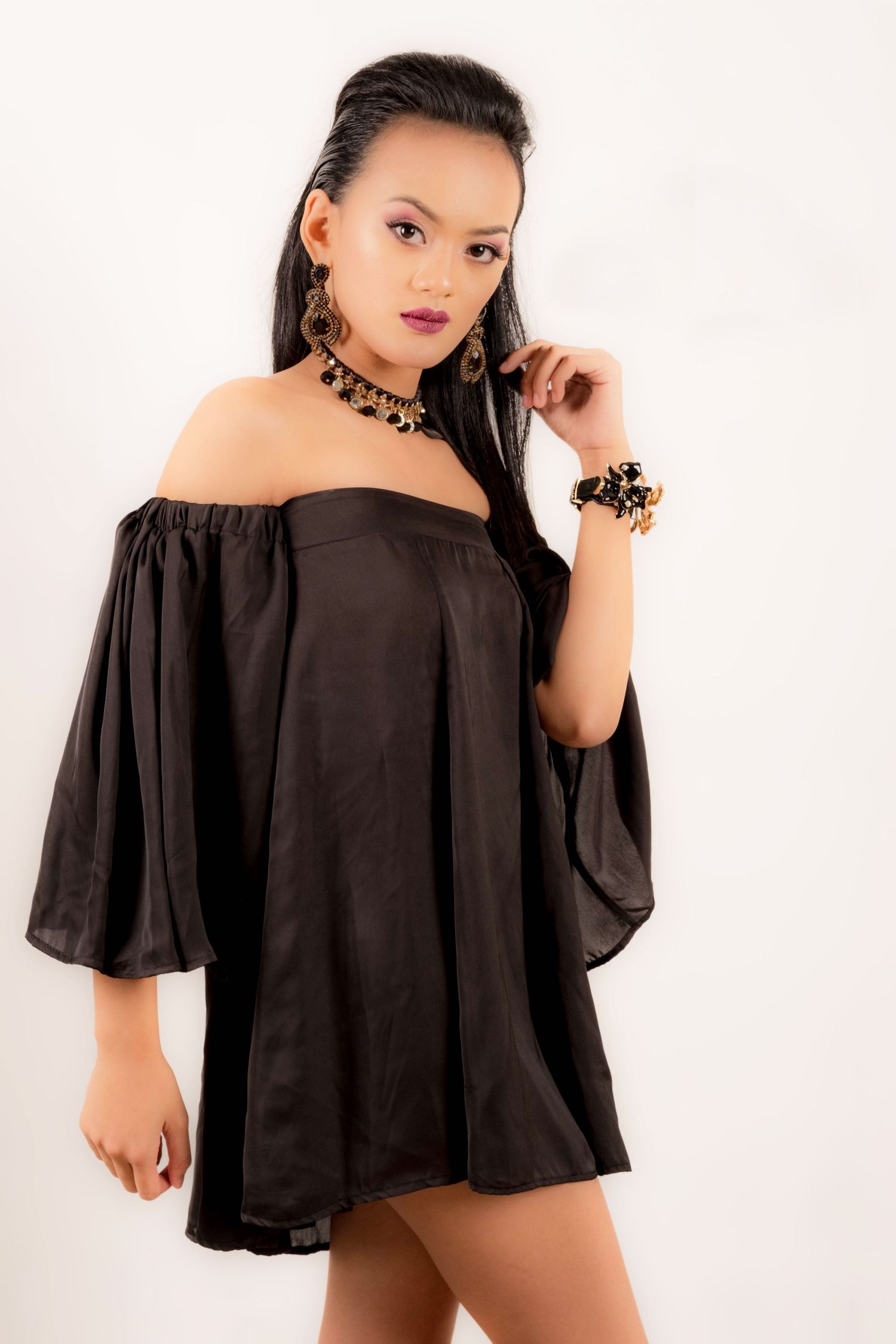 Fashion photo series in black off-shoulder flowing top against white background.